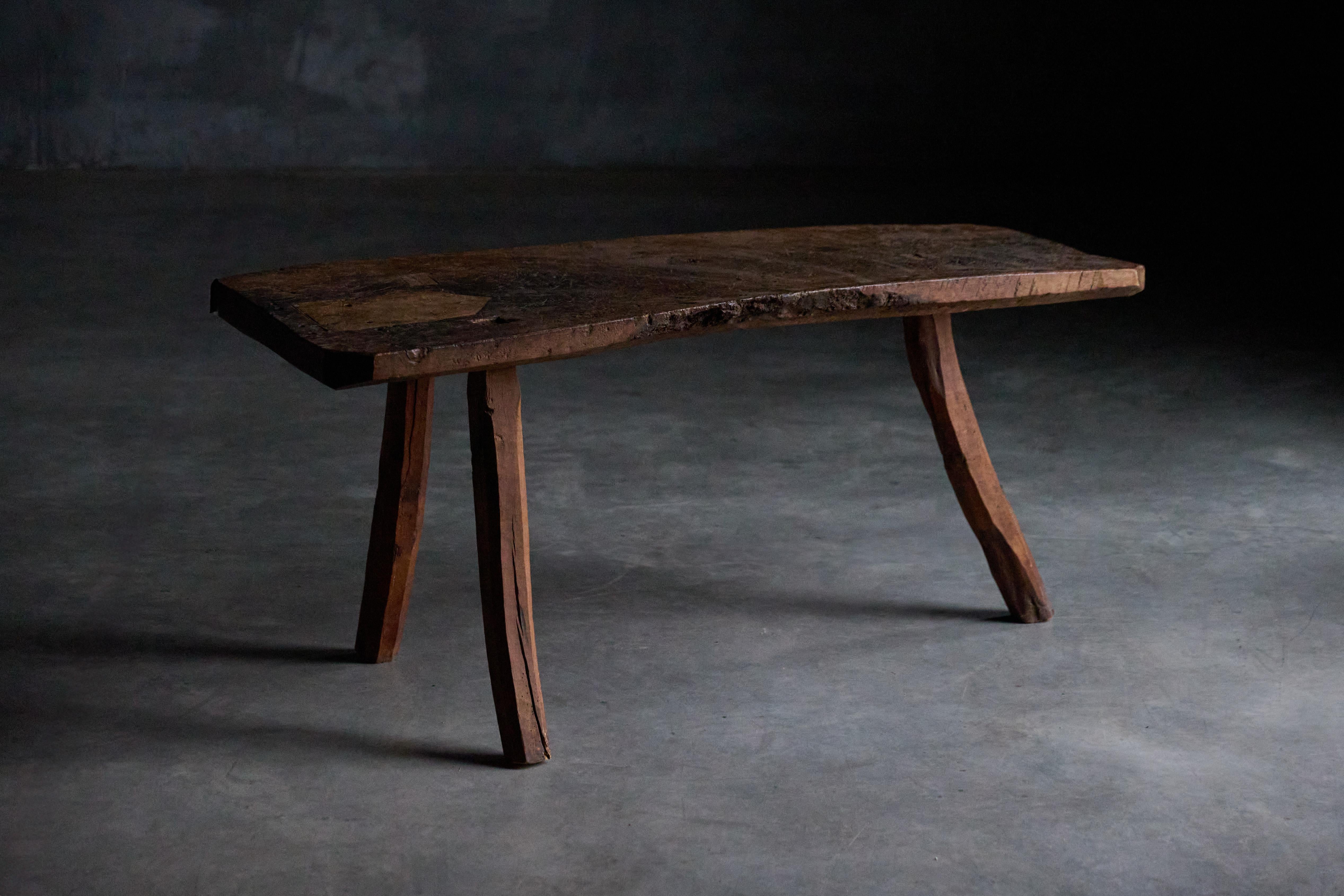Cette table d'appoint tripode en bois sombre du XIXe siècle incarne l'essence du wabi-sabi, qui célèbre la beauté dans l'imperfection. Sa surface altérée et ses pieds tripodes asymétriques dégagent un charme rustique. La patine naturelle et les