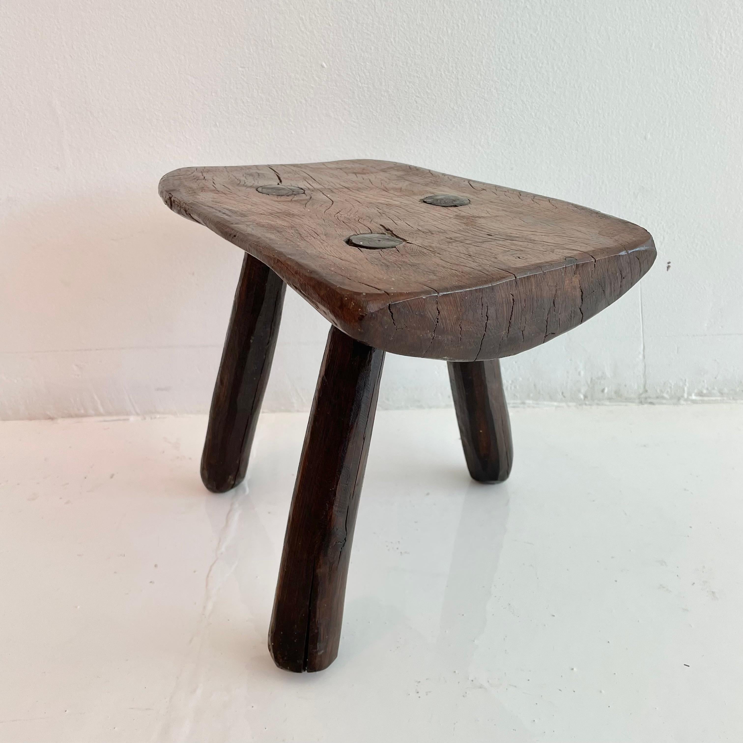 Stubby wooden tripod stool, made in France, circa 1950s. Thick brutalist seat with three rounded legs. No nails or hardware. Great shape and character. Petite stool with beautiful presence. Great vintage condition. Perfect for books or objects as