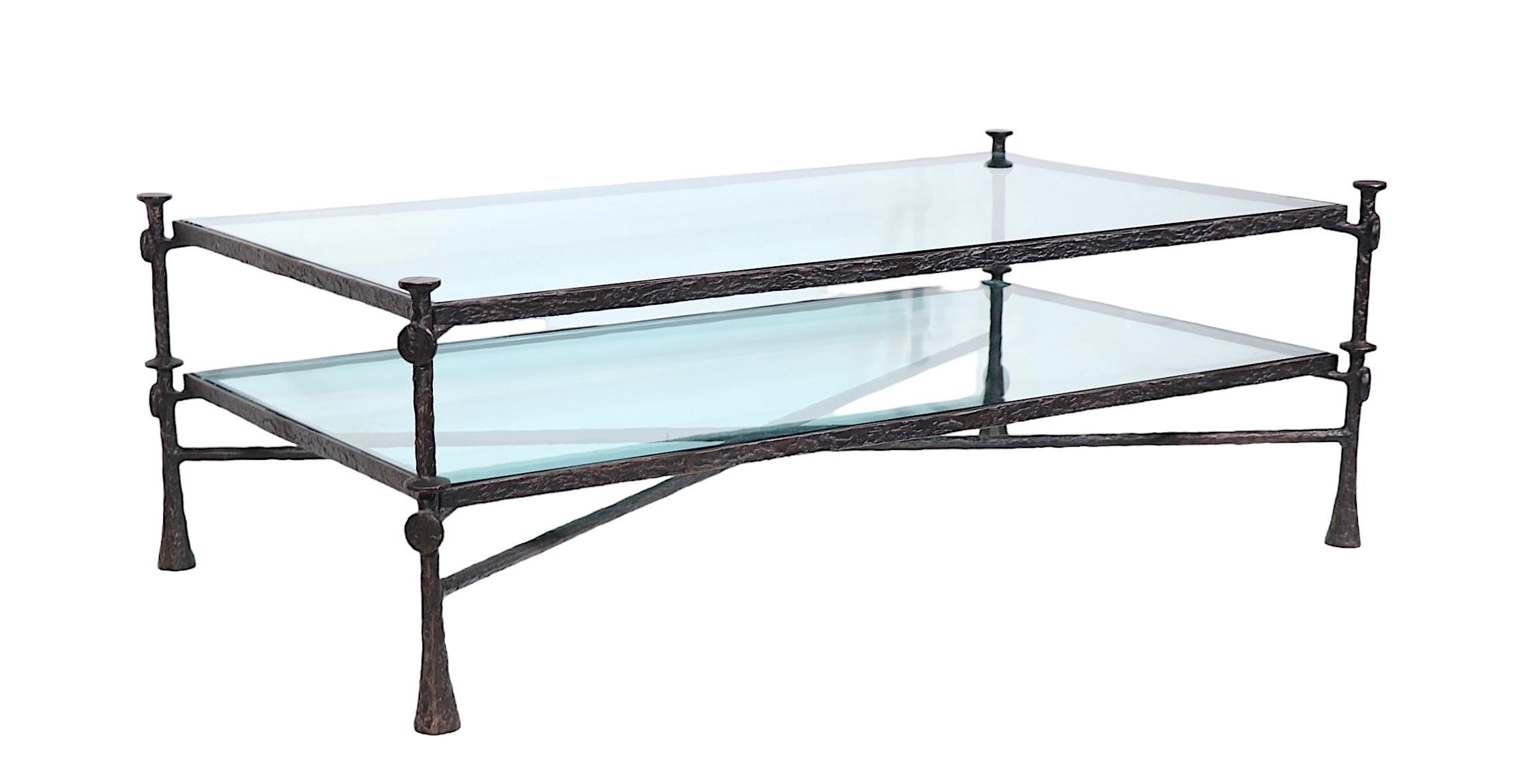 Incredible Brutalist style coffee table executed in faux hammered  bronze ( iron ) , and thick ( .75 in. ) bevelled  tempered glass. The table features two surfaces, lower surface H 10.5 in. x upper surface H 18.5 in. which are supported by the iron