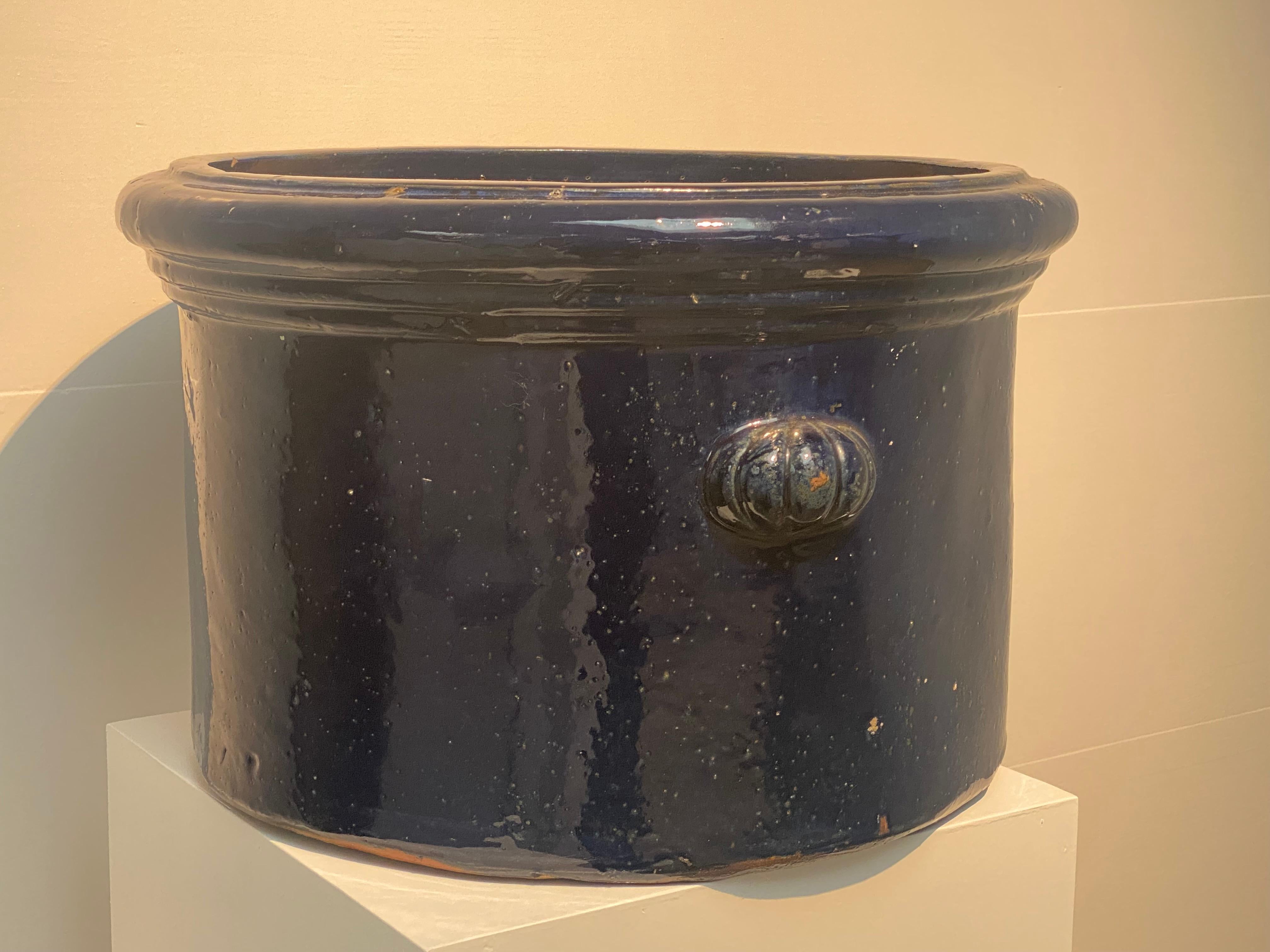 An elegant Vintage and brutalist Terracotta Planter in an
dark Blue Color, Spain from around the 1970 ies,
nice circular form, simple design with just to handles,
warm shine and patina of the glazed terracotta,
to be used inside as well as