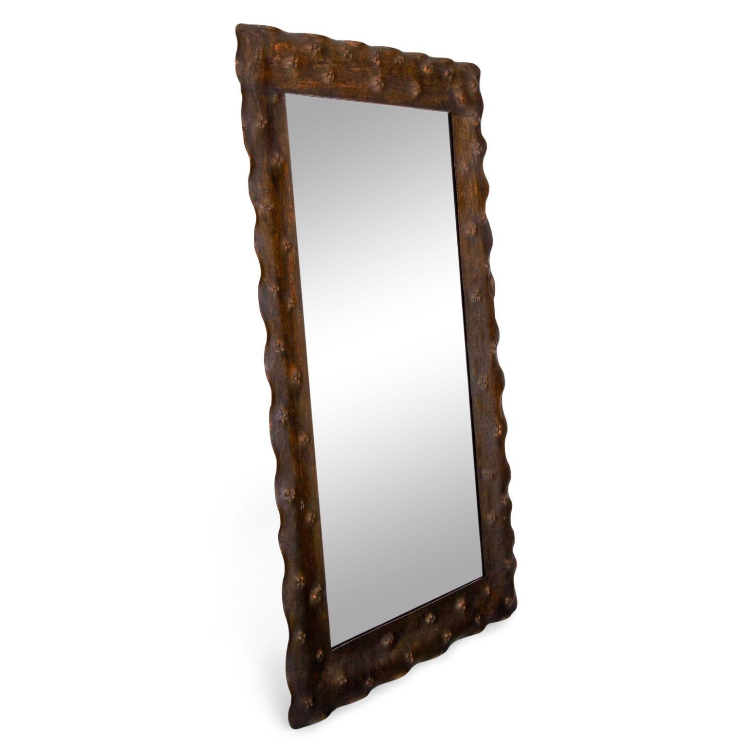 Rectangular wall mirror in a hammered and slightly wavy metal frame.