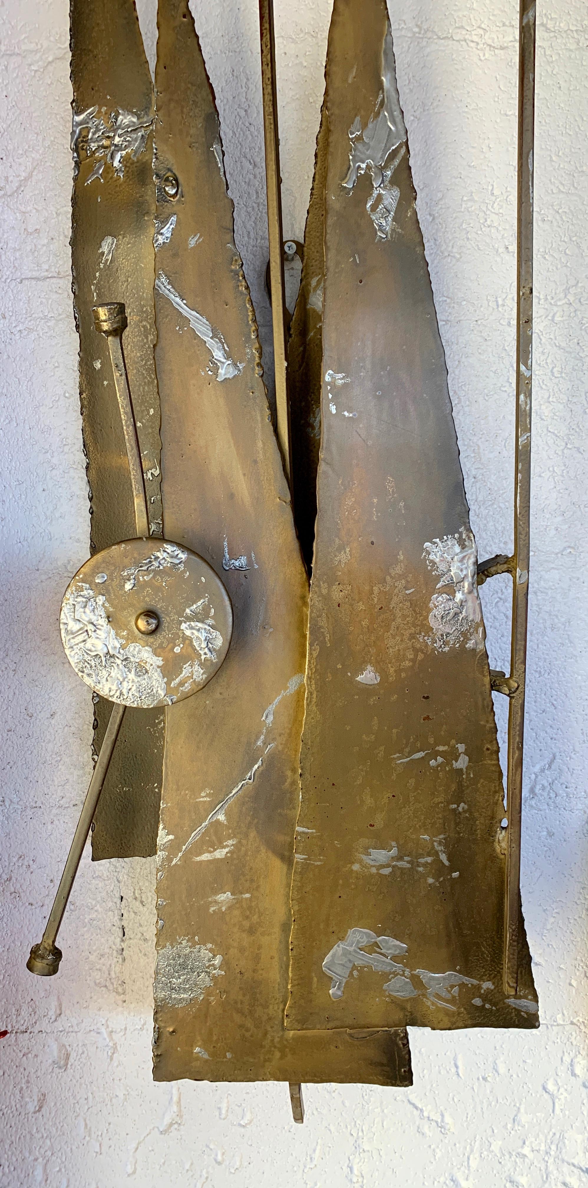 A vintage 1970s Brutalist metal wall sculpture. Patinated metal, likely iron by the weight, It is not signed that we can see. It has been re-sprayed with finish and polished and cleaned up. Measures approximate 55 inches long with a bend to the