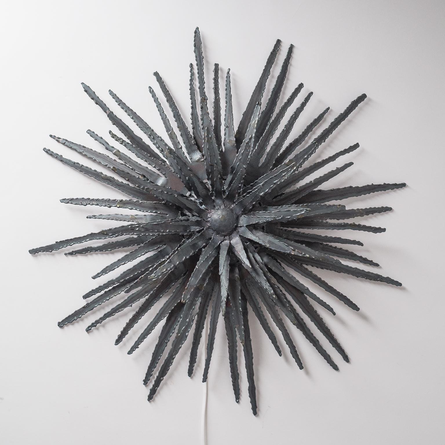 Rare brutalist wall sculpture/light from the 1960s. Made of lacquered multi-layer torch-cut sheet metal this has a wonderful abstract organic structure, akin to a sea-urchin or thistle. One brass and ceramic E14 socket with new wiring.