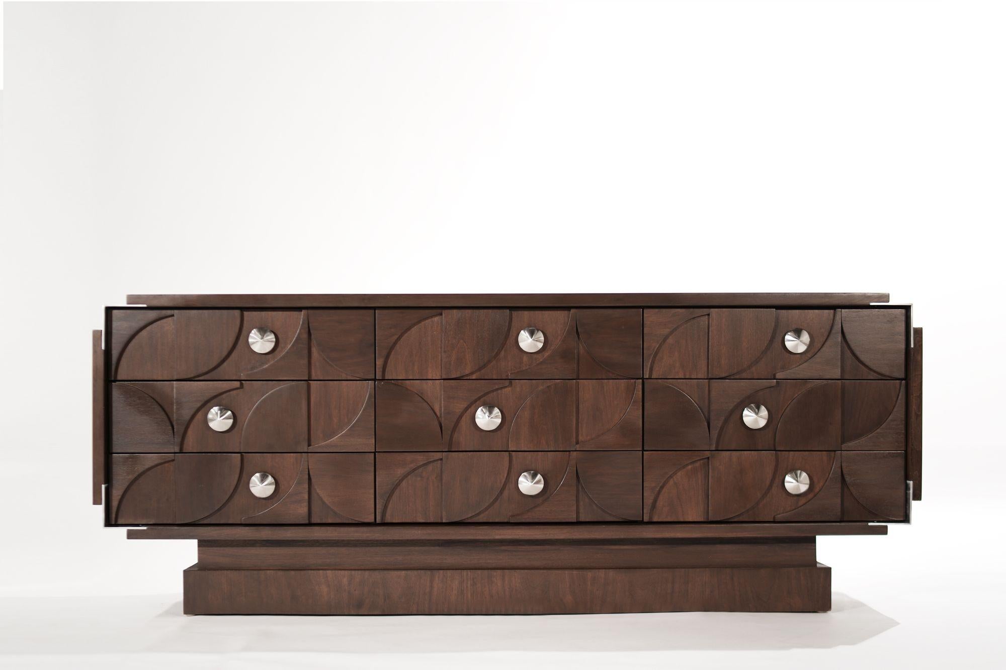 A brutalist-style dresser executed in walnut featuring nickel accent corners and hardware. The nine drawers provide ample storage space. Completely restored.
 
Other designers from this period include Paul Evans, Paul Frankl, Vladimir Kagan, and
