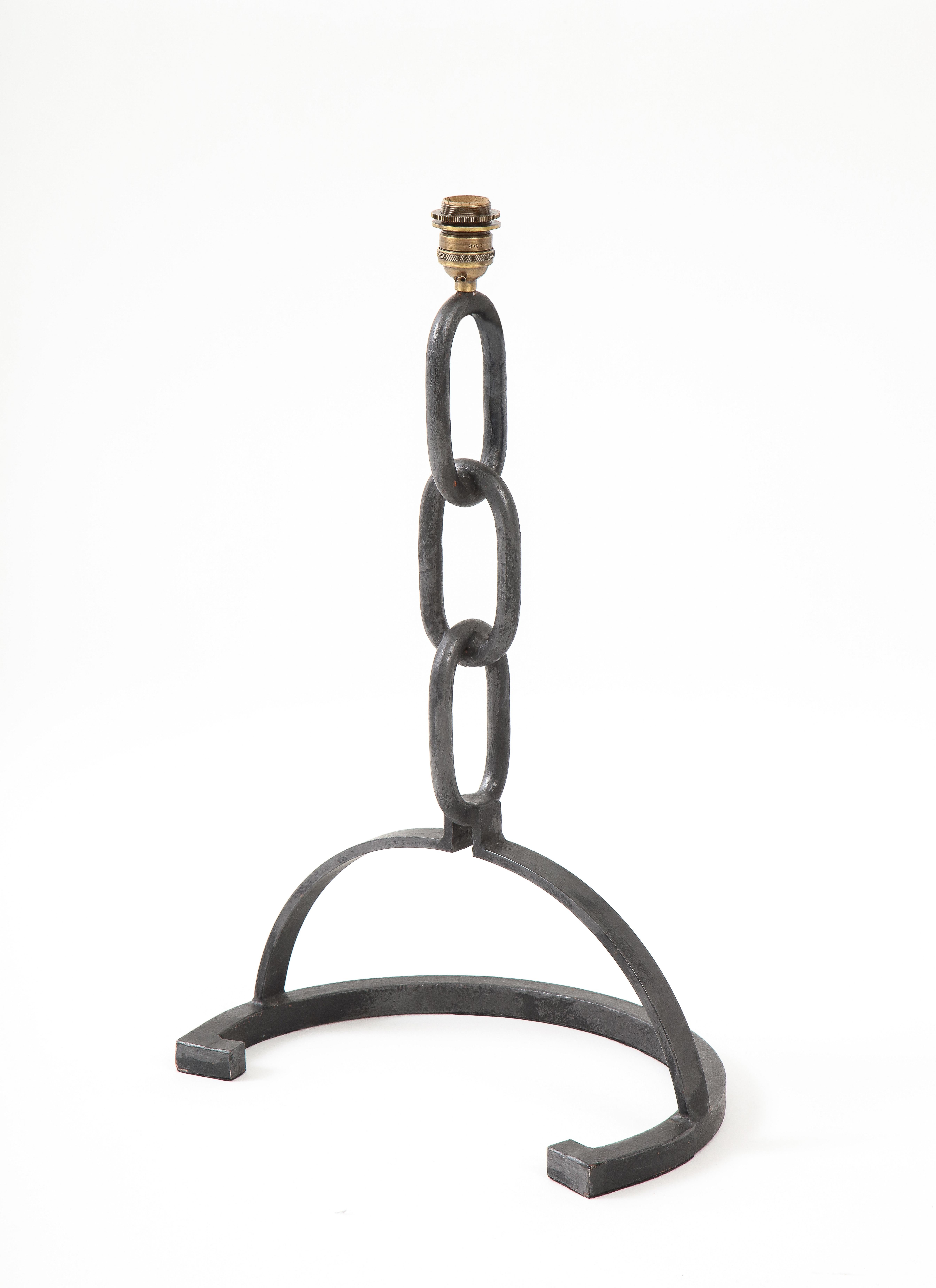 Brutalist cast iron table lamp made of welded chains links with a horseshoe shaped base.