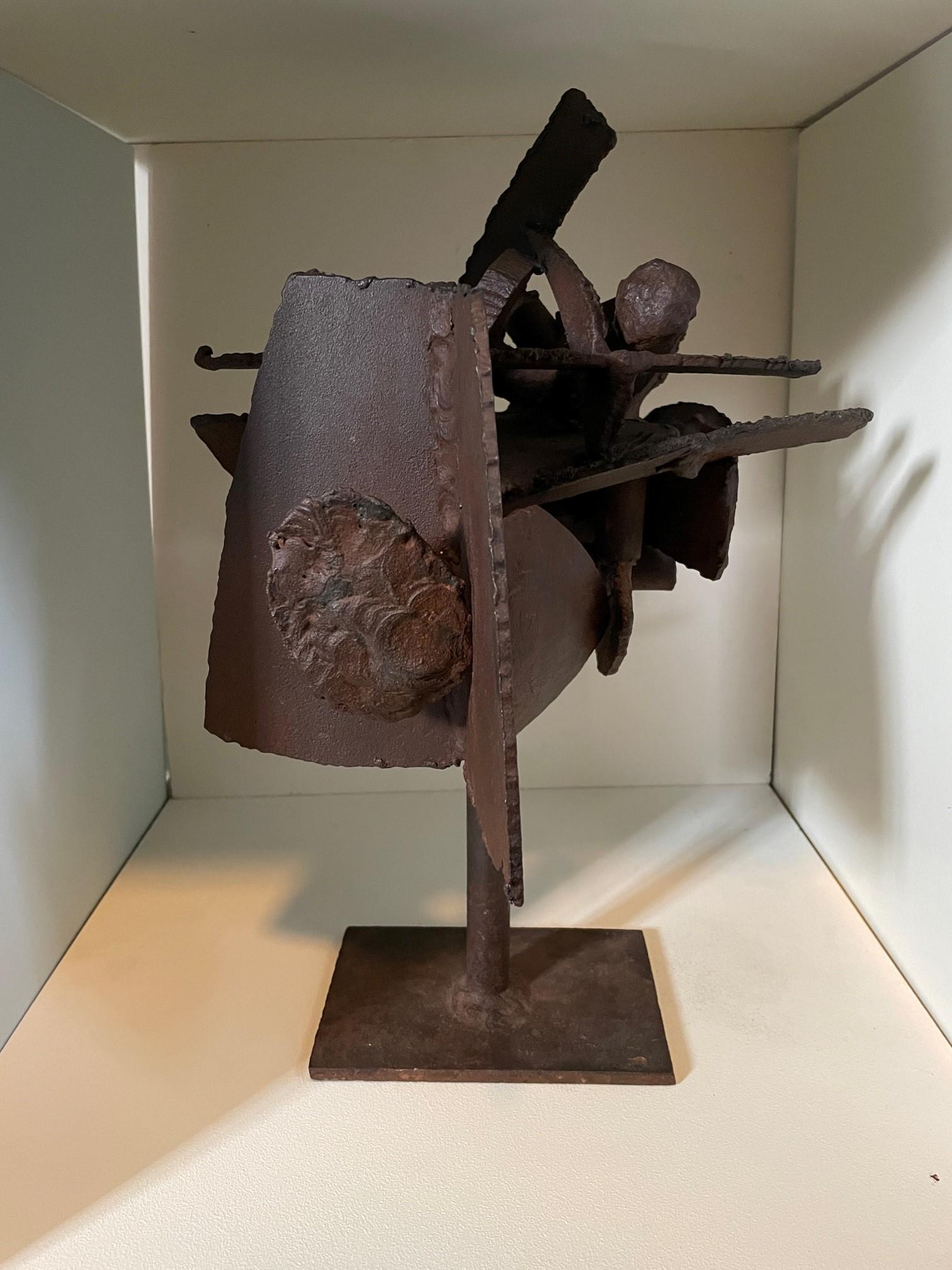 A striking Brutalist welded iron sculpture depicting an abstract geometric composition upon a tubular stem, above a rectangular base, in the manner of Herbert Ferber (American, 1906-1991). A great example of the brutalist design, reminiscent of