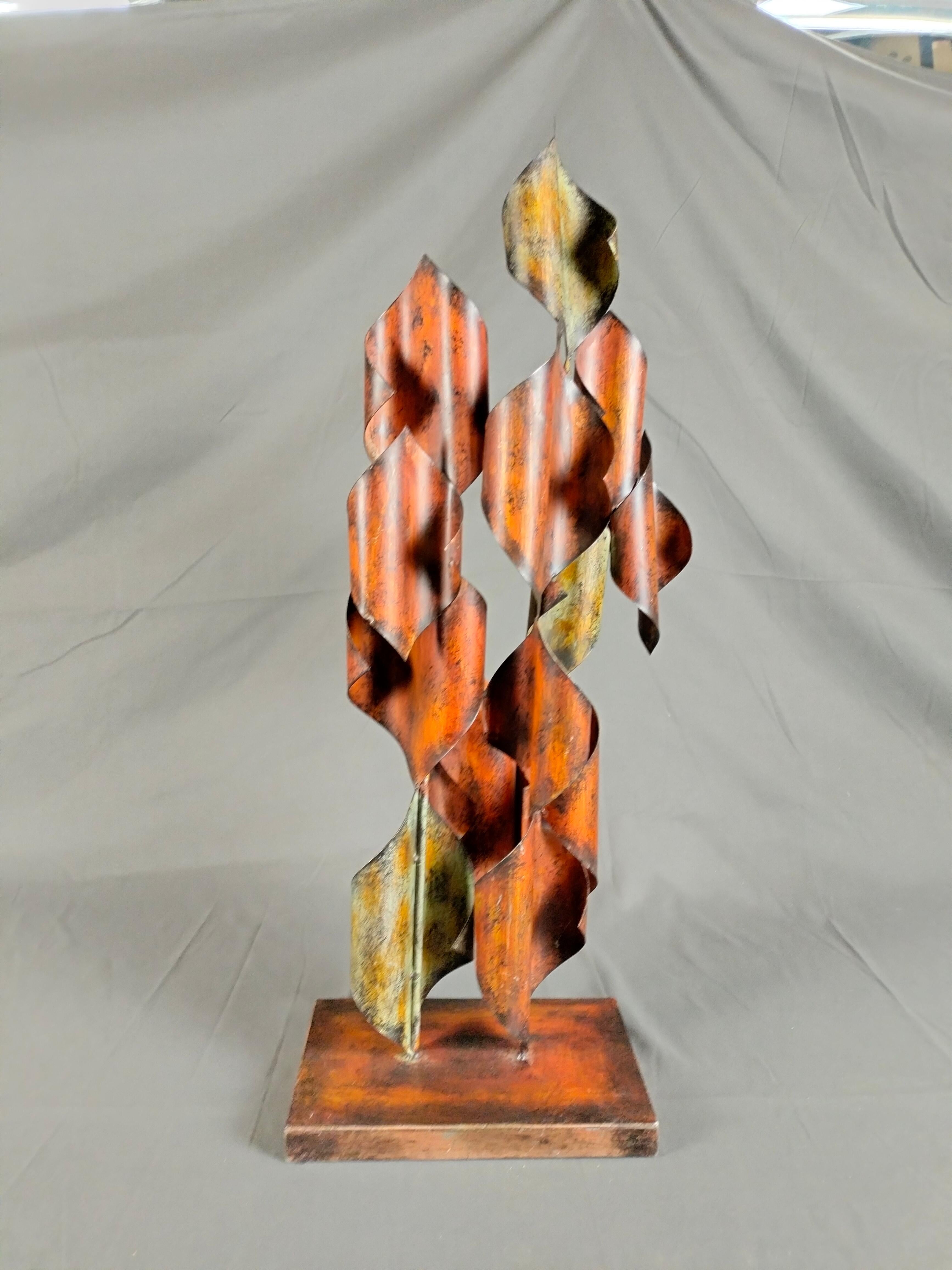 A patinated steel abstract sculpture in the style of Curtis Jeré. Manufactured in the 1970's. The leaf-shaped designs are folded and overlapped to resemble a tree. The piece is unsigned.