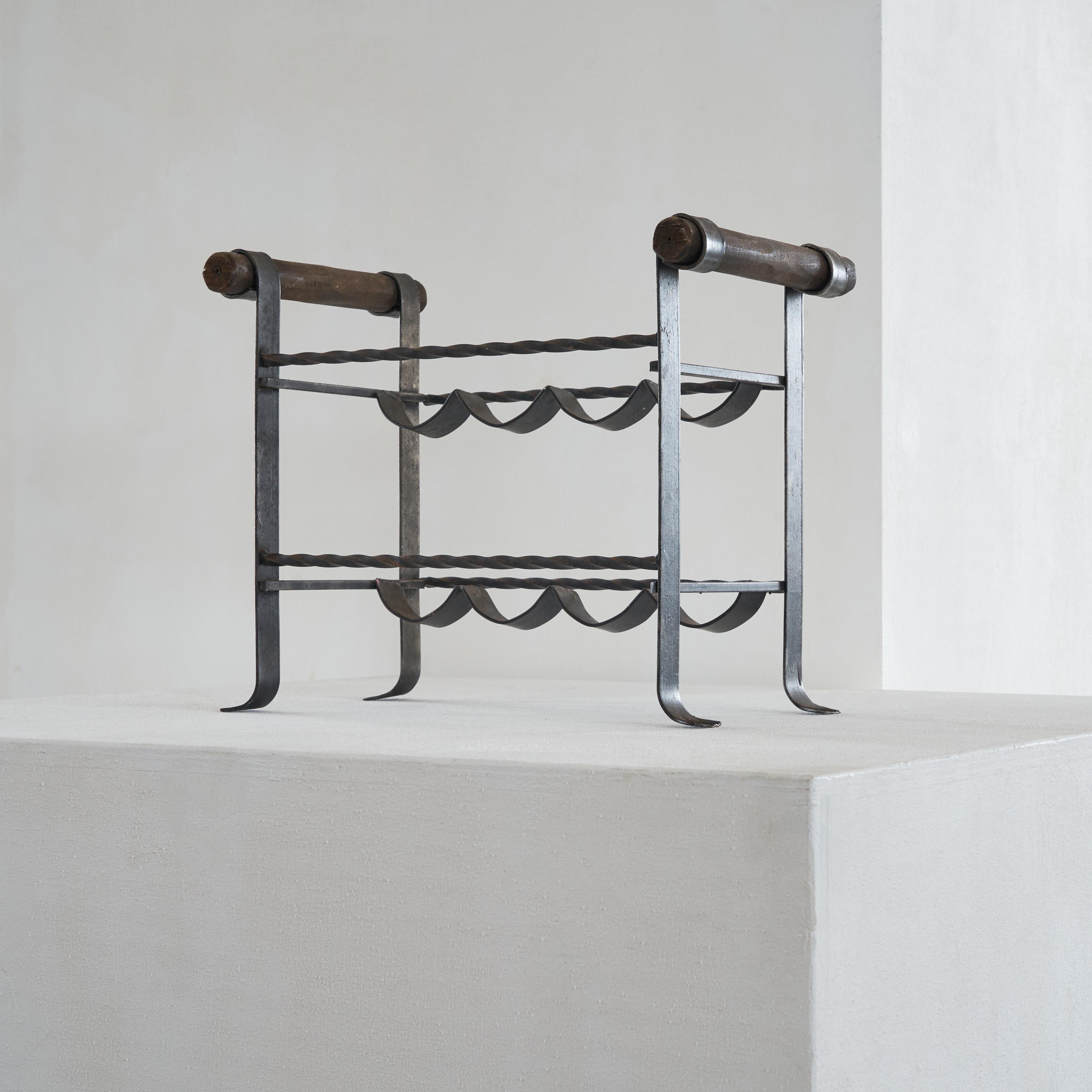 Brutalist wine rack in wrought iron and wood 1960s.

This is a wine rack in wrought iron and wood with a very distinct Brutalist design. The the warm wood and the wrought iron do compliment each other in a very midcentury fashion. The turned rods