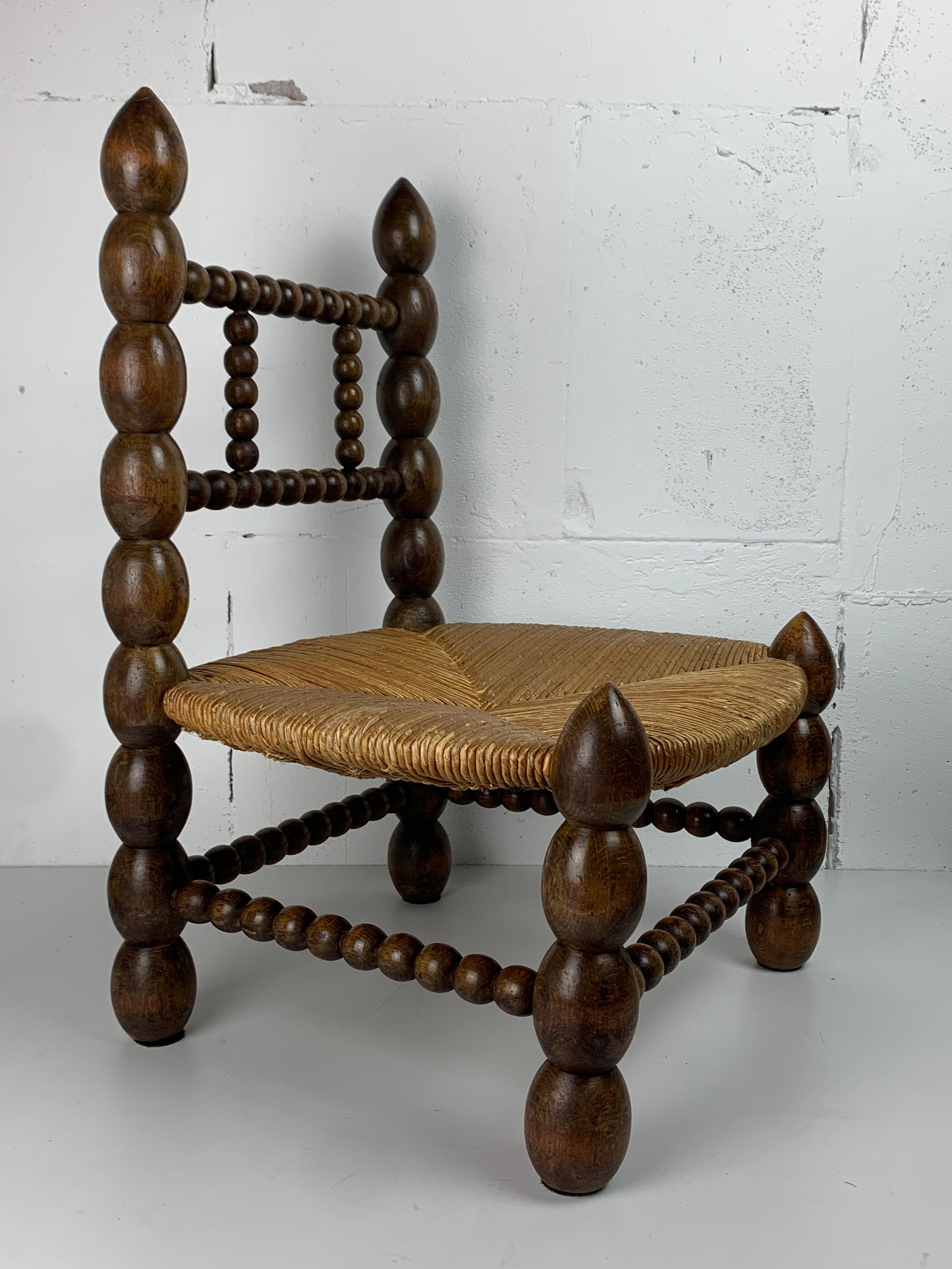 French Brutalist wood turned bobbin low rush chair in the style of Charles Dudouyt