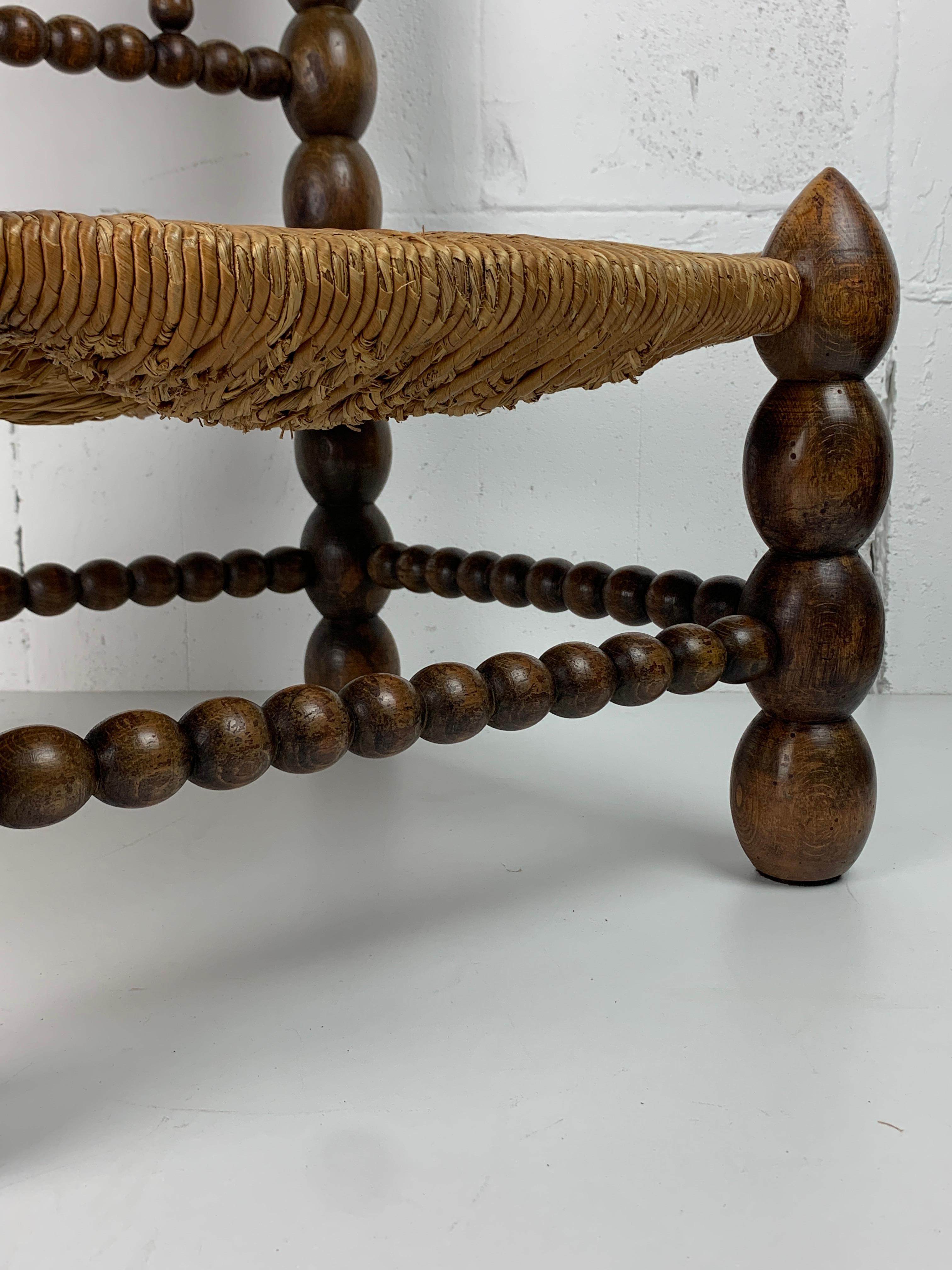 Oak Brutalist wood turned bobbin low rush chair in the style of Charles Dudouyt