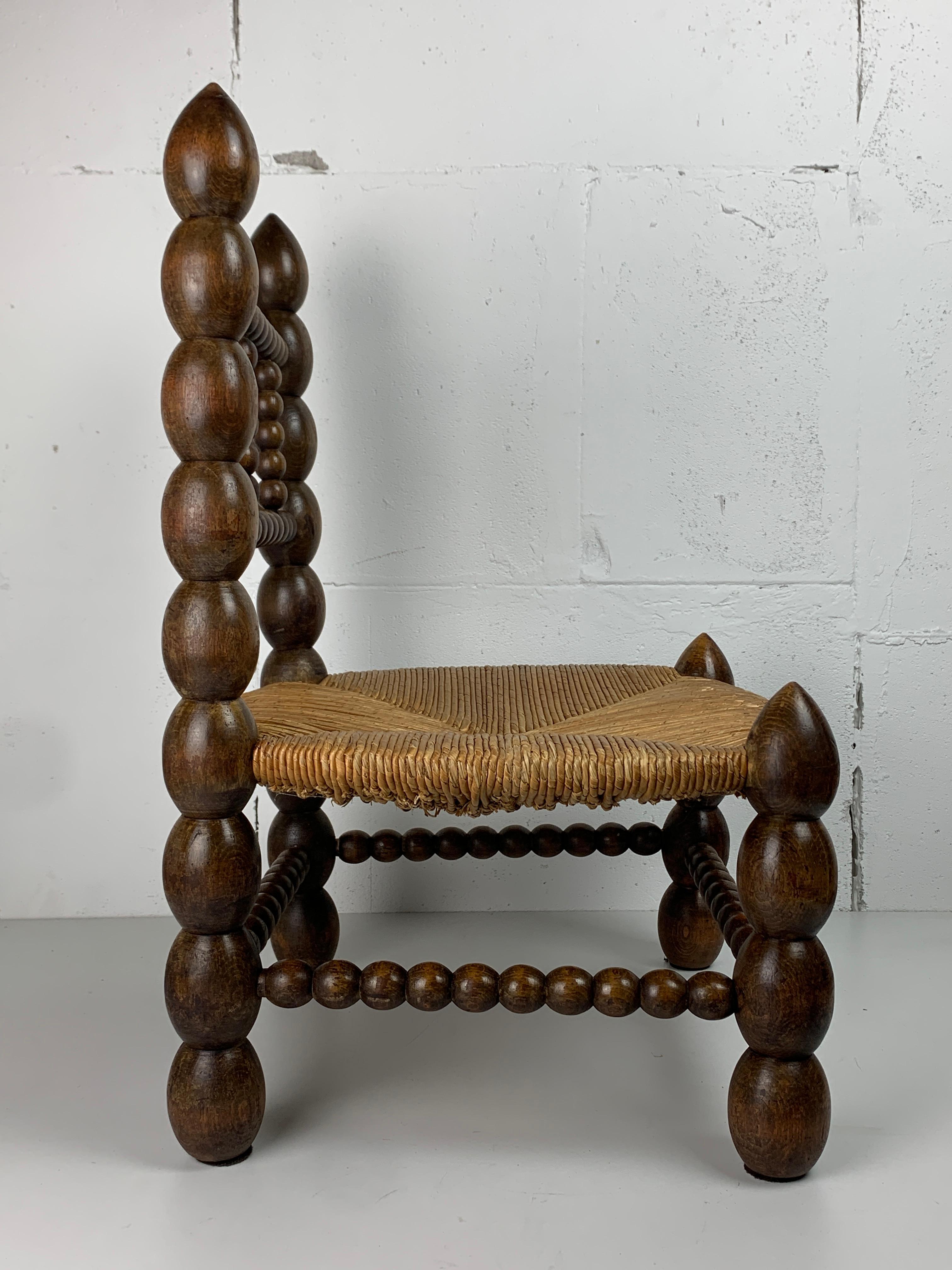 Brutalist wood turned bobbin low rush chair in the style of Charles Dudouyt 1