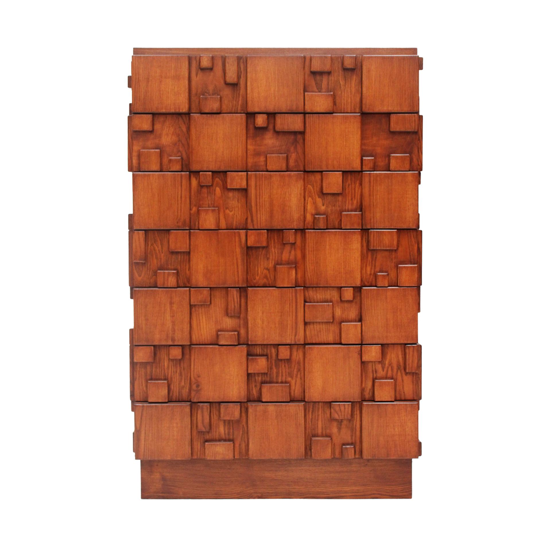 Handcrafted chest of drawers made of solid oak, featuring a bold brutalist design with sculptural, geometric drawer fronts. The piece includes seven spacious drawers, offering both functional storage and a strong visual presence. Crafted in Italy,