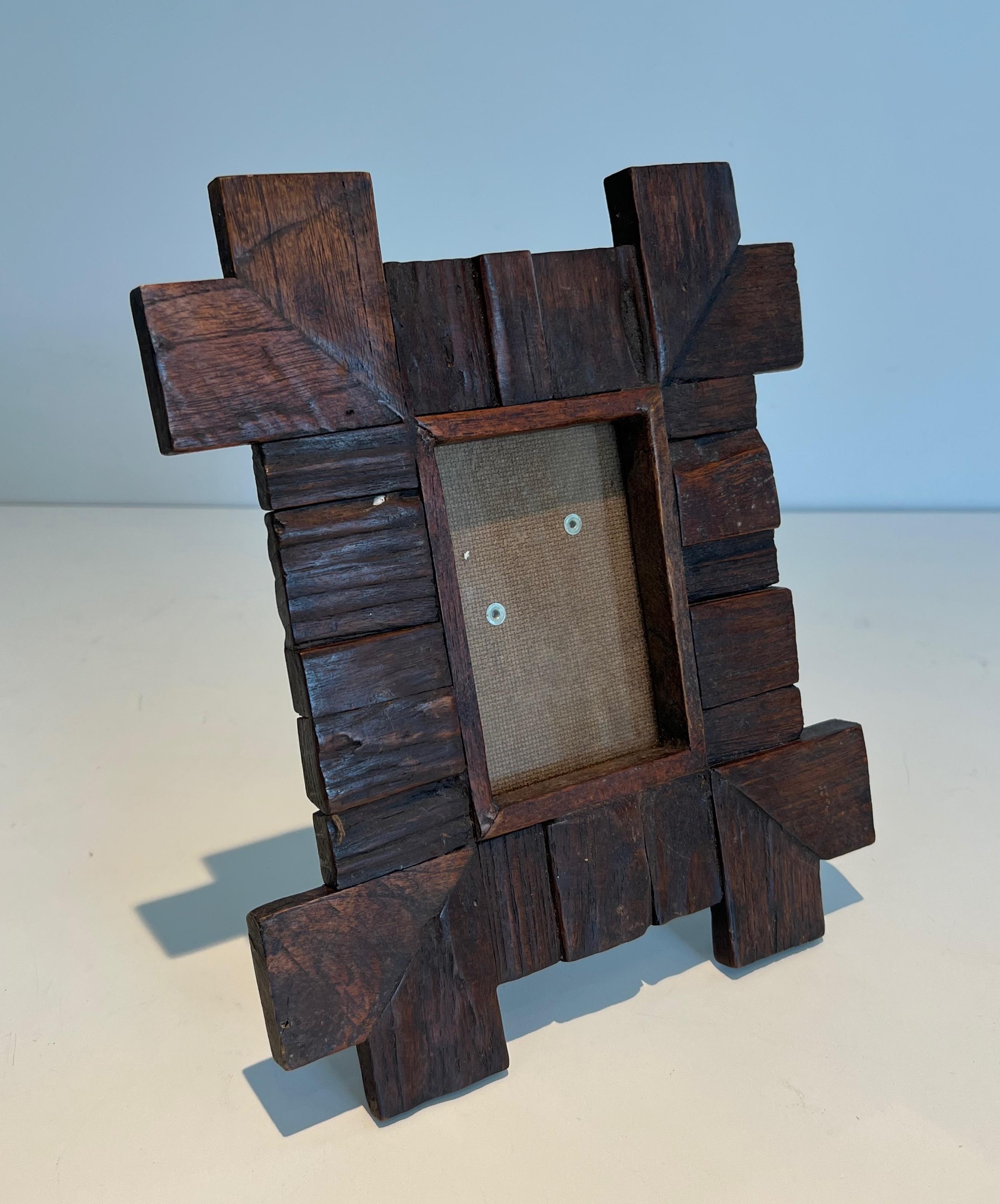 This brutalist picture frame is made of carved wood. This is a French work. Circa 1950