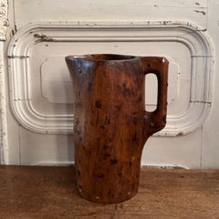 Brutalist wooden pitcher with monochrome finish, enhanced with nails, folk art