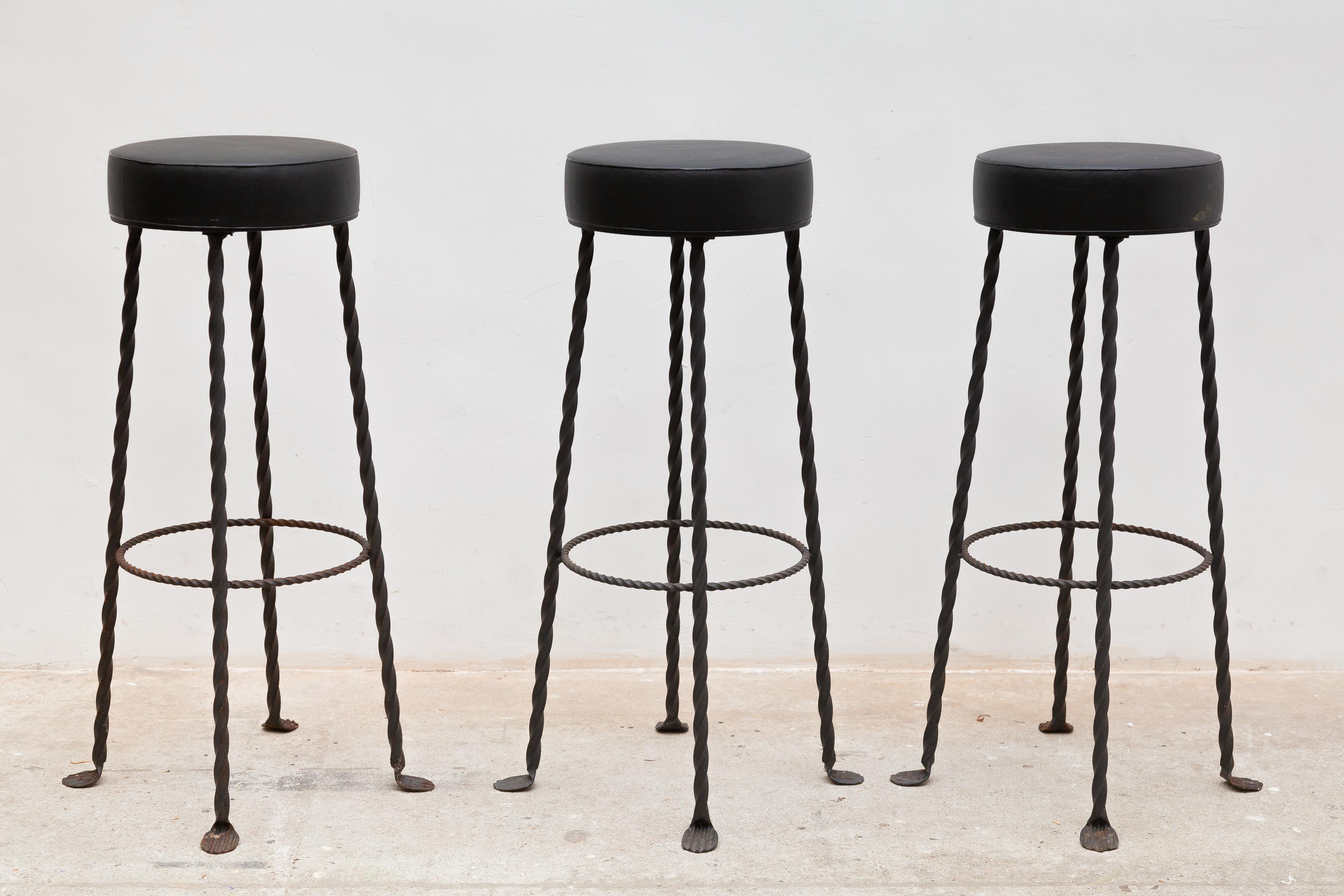 A set of three brutalist styled bar foot stools featured in wrought iron and a black similar seat,France c1960s. The stools are in good original condition and have a nice patina from age and usage. The stools are priced and sold in a set of