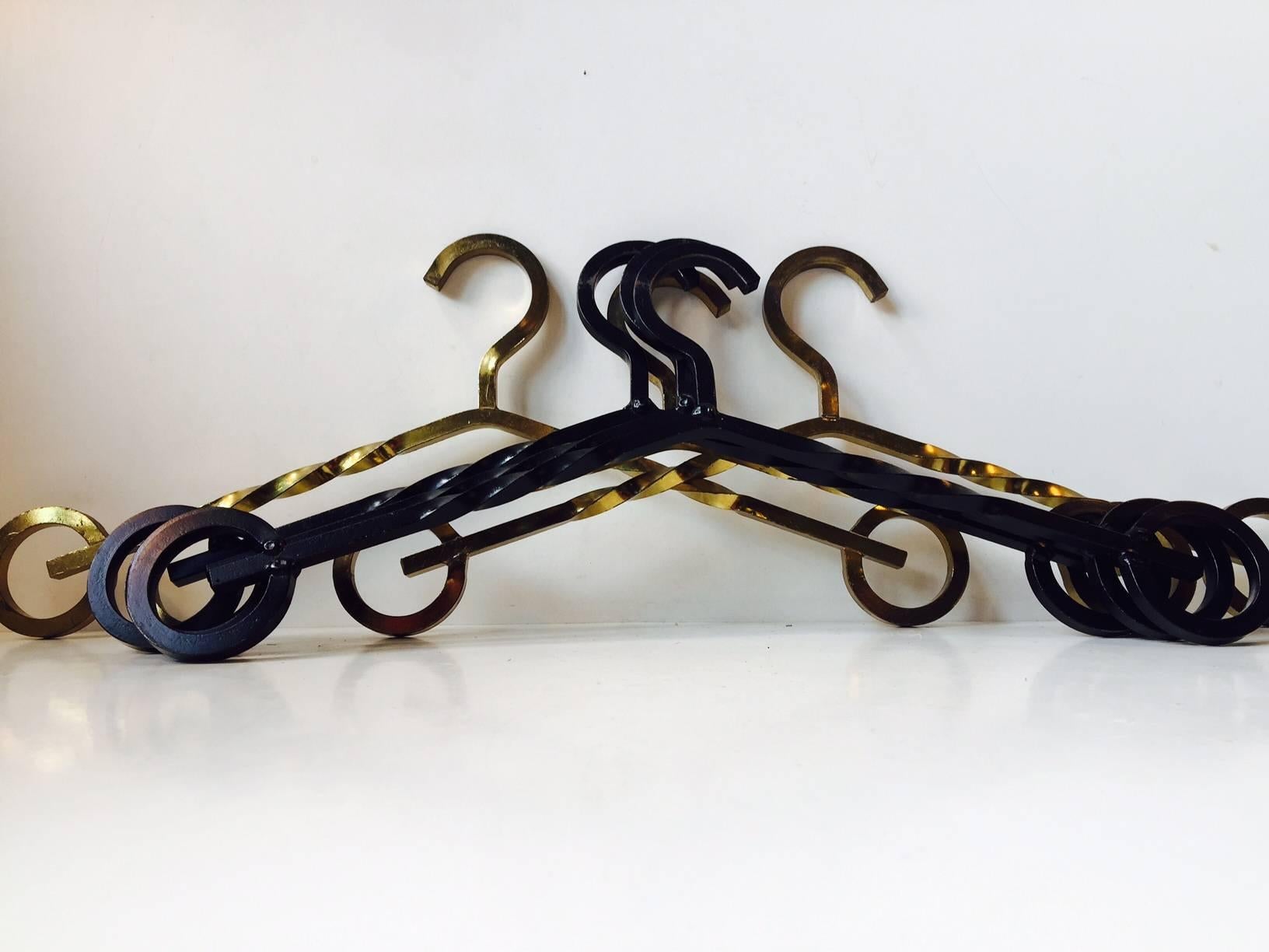 Hand-welded in Denmark during the 1970s this set of twisted iron and brass coat hangers stylistically displays midcentury Brutalism. The price is for the set of six.