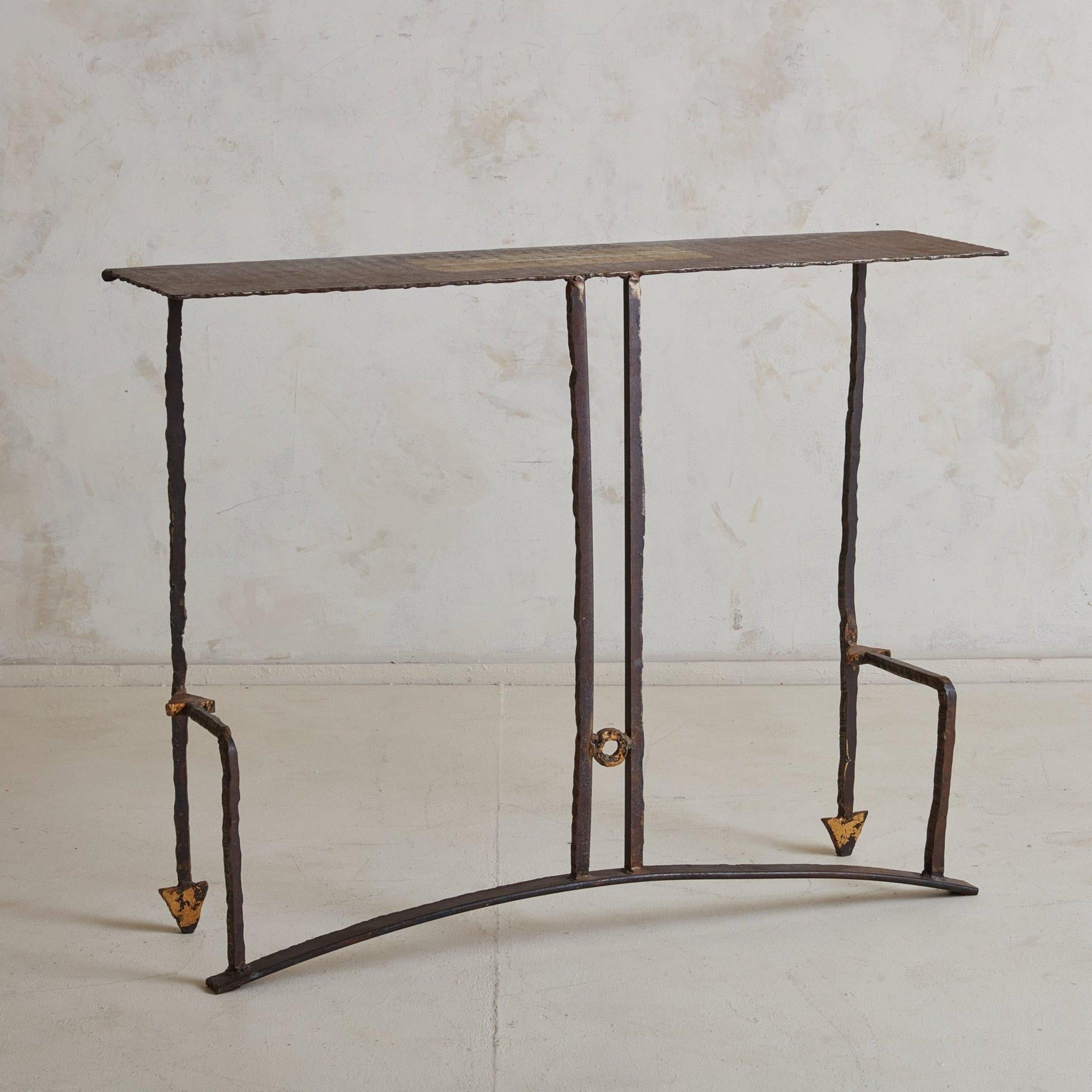 A brutalist French patinated wrought iron console table designed by Jean Jacques Argueyrolles (1954-). This sculptural console has a rectangular tabletop with four iron legs and an arched base. It has painted gold accents and features geometric