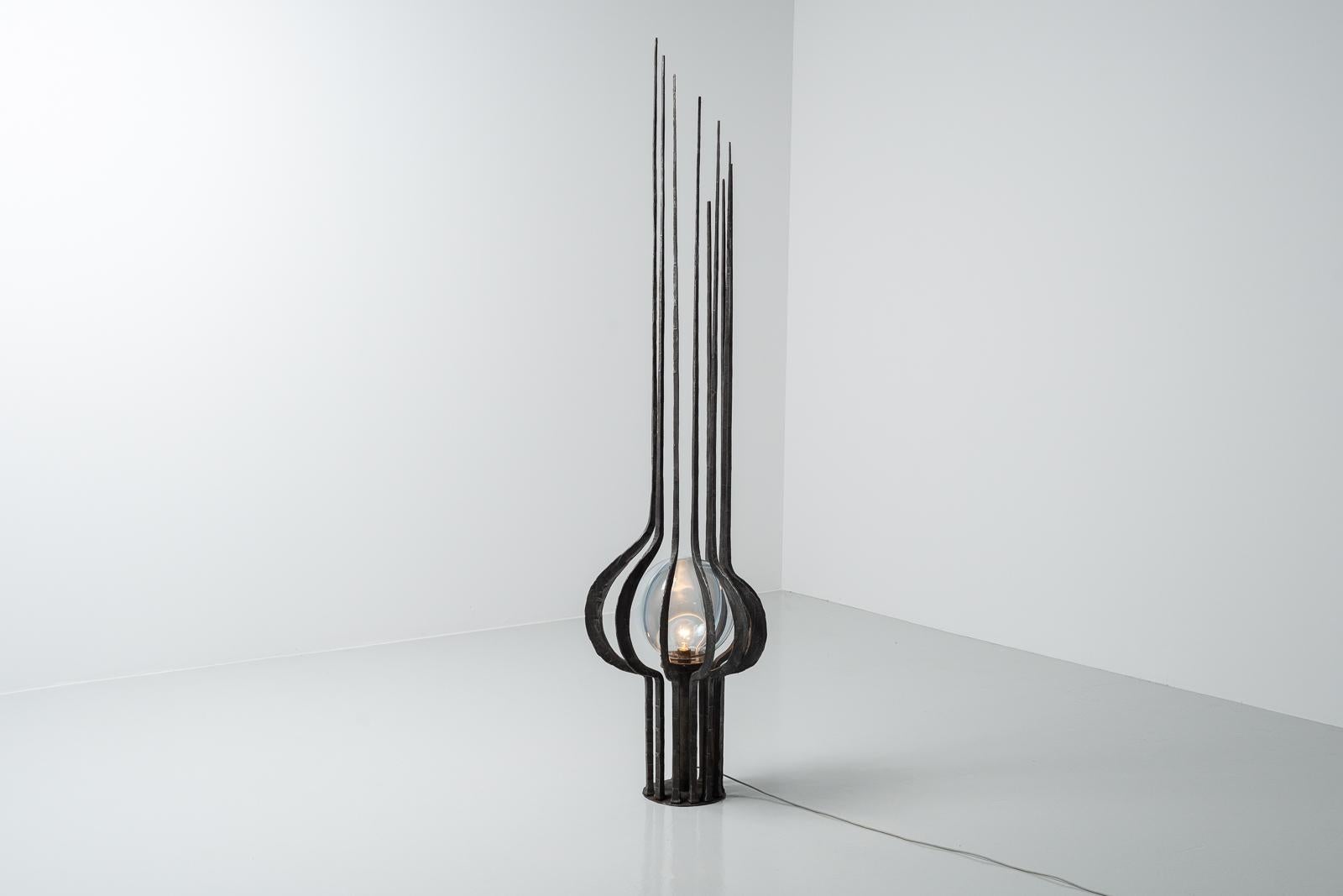 Monumental sized and very impressive brutalist floor lamp made by unknnown designer or manufacturer but has a glass sphere shade by Tony Zuccheri for Mazzega. The lamp was hand made in Italy, ca 1970s. It is made of solid wrought iron hammered