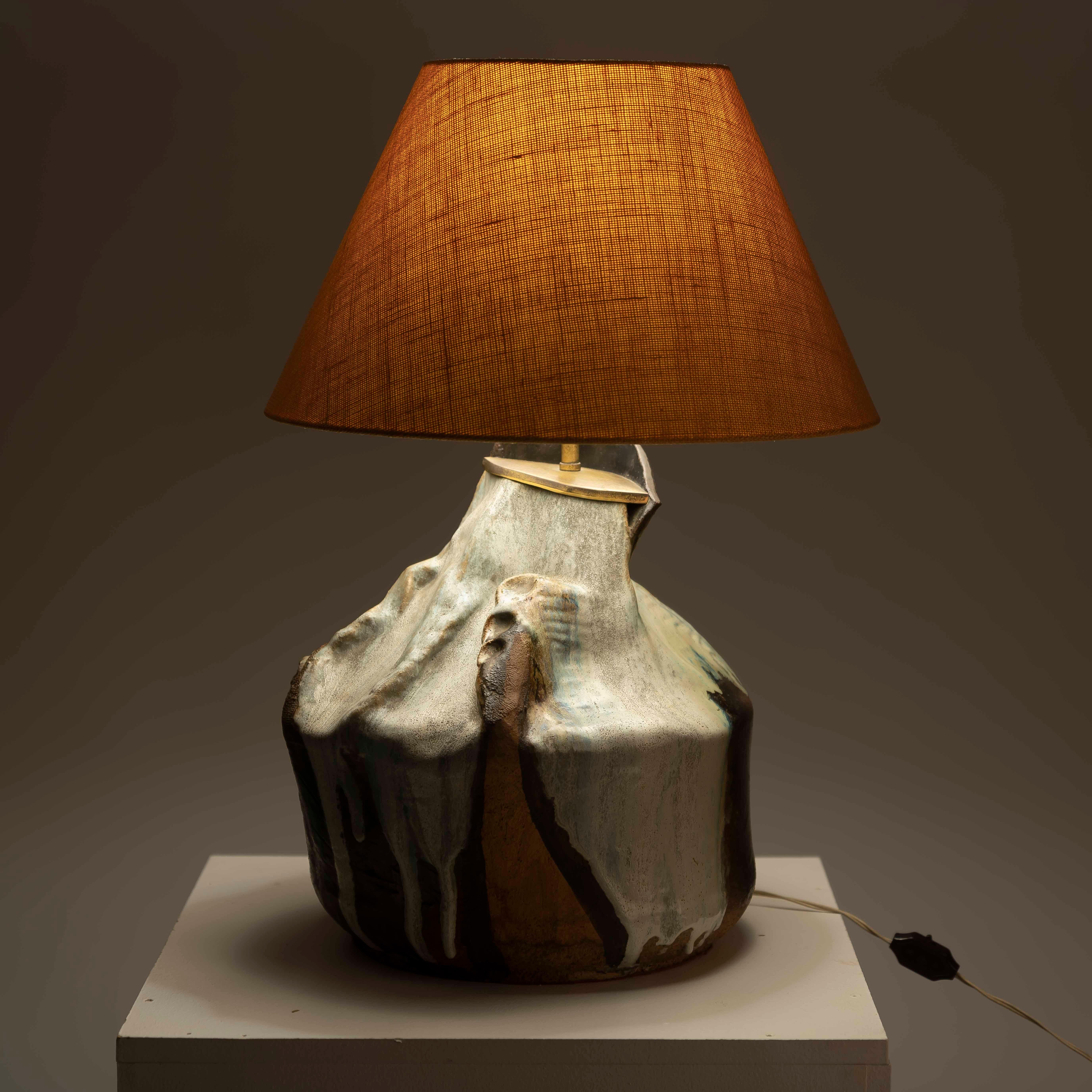 Immerse yourself in the rugged allure of Brutalist design with the XXL glazed ceramic table lamp from the 1980s. This striking piece is more than just a source of illumination; it's a bold statement of artistic expression and architectural