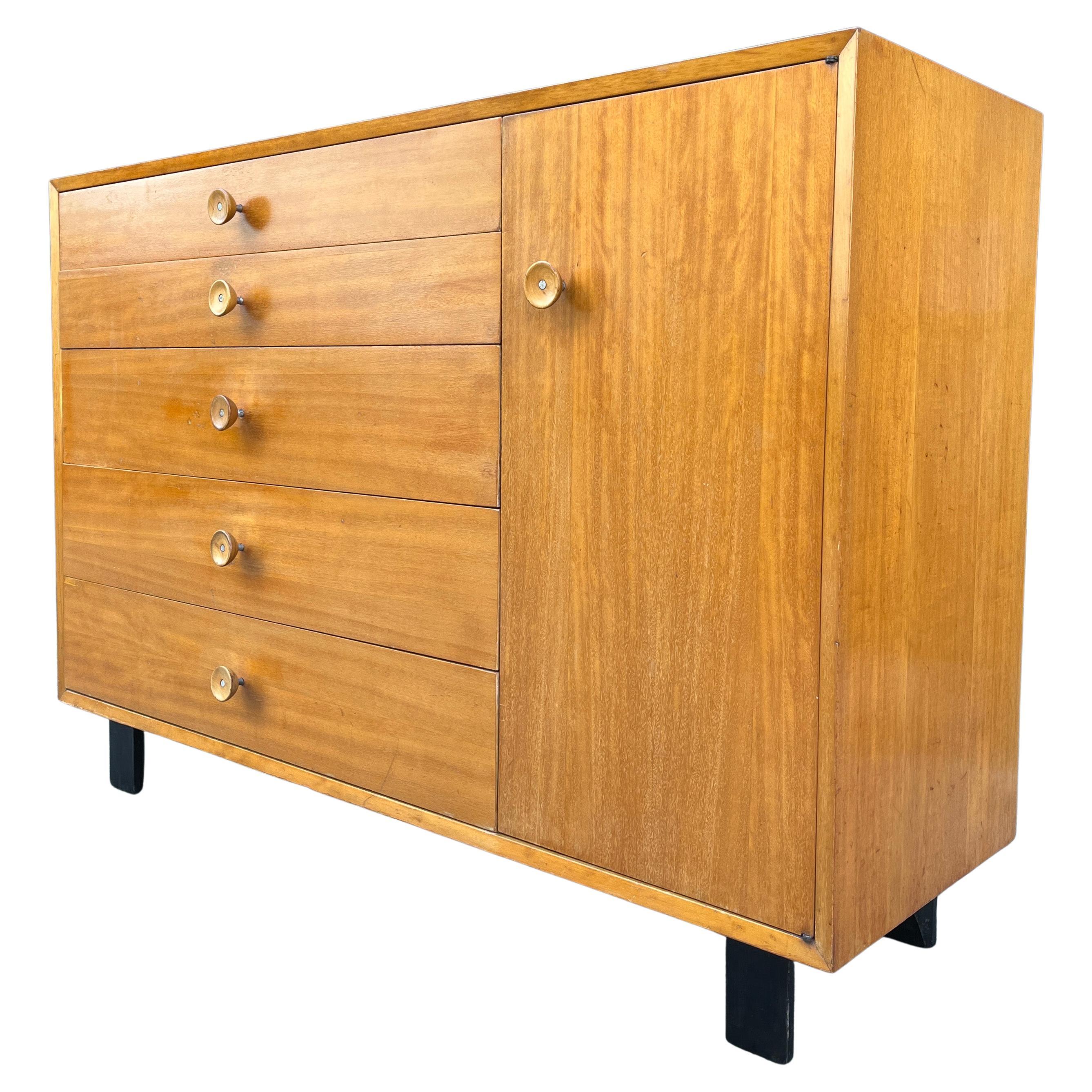 George Nelson designed this chest or cabinet, model #4621, as part of Herman Miller’s modular basic storage components. A five-drawer Primavera wood dresser with side cabinet containing two adjustable shelves. Original foil George Nelson-Herman