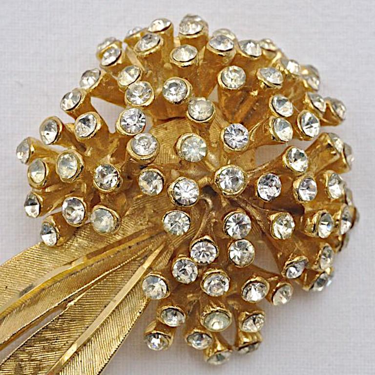 BSK beautiful brushed and shiny gold plated brooch, featuring a spray of clear rhinestones. Circa 1950s. Measuring length 7.2cm / 2.8 inches by width 3.4cm / 1.3  inches. There are a few replacement rhinestones.

This is a large and glamorous