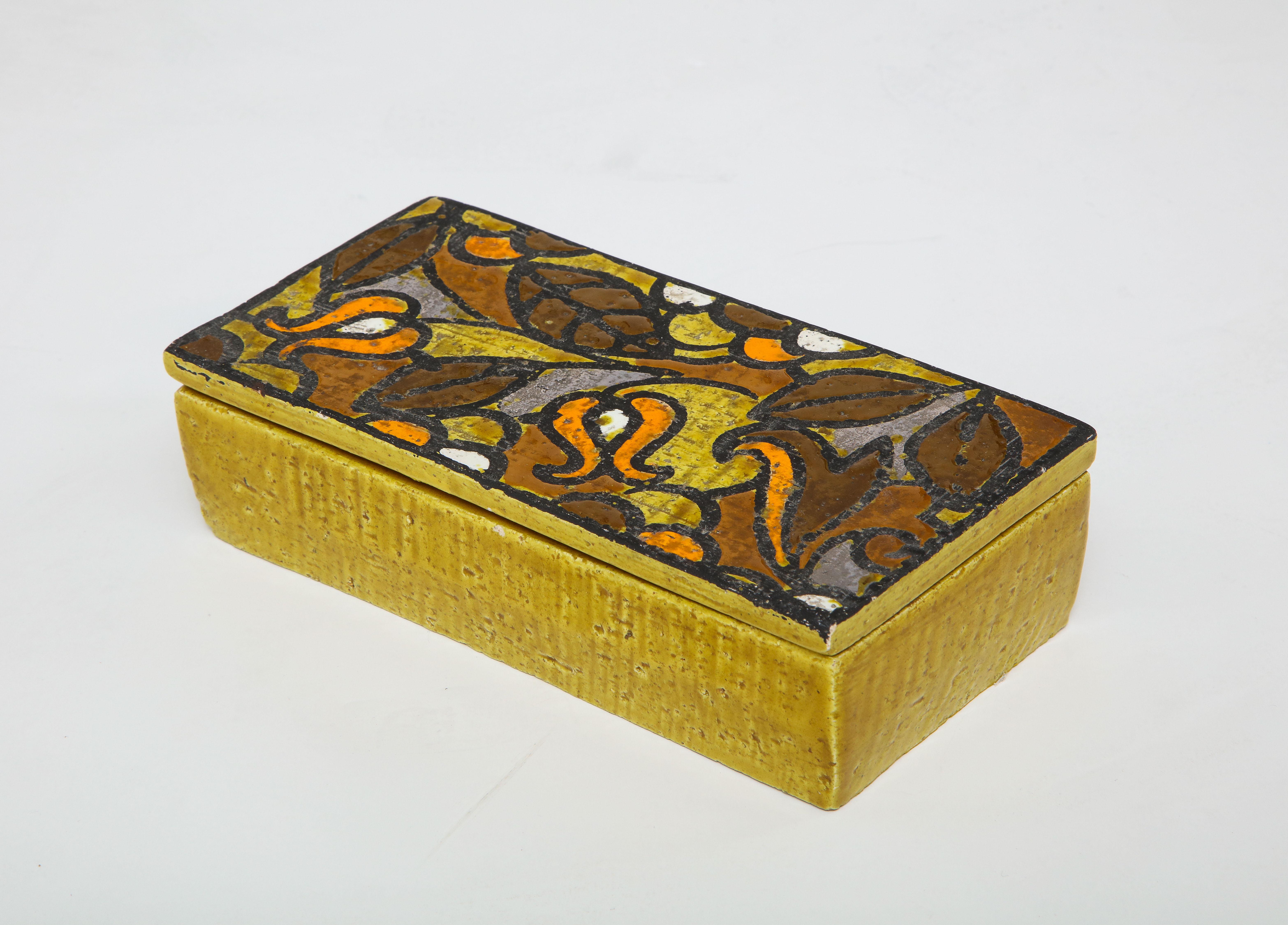 Senfgelbe Keramikdose mit kontrastierendem Deckel mit stilisiertem Blumenmuster in Umbra, Orange, Gelb und Weiß. Unterschrieben.