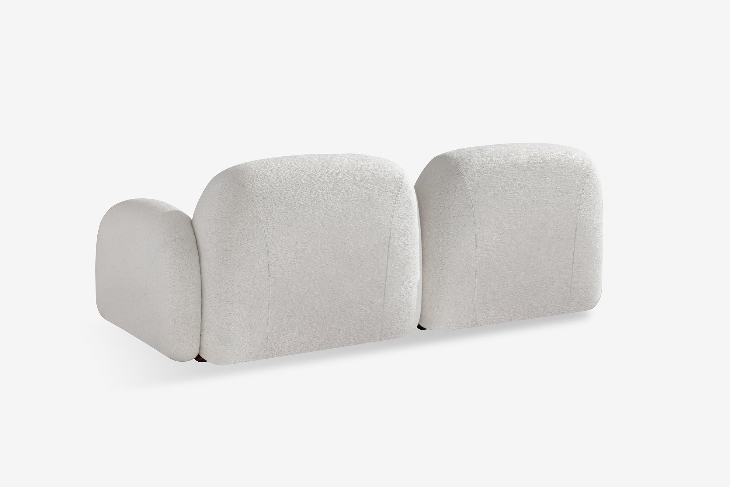 Sofá tapizado de dos plazas con o sin curvas y base de madera. Estructura de contrachapado, abeto y tablero duro con certificación EPA. Acolchado con capas de poliuretano de célula abierta y Dacron, con correas elásticas. Curvado en capas de madera