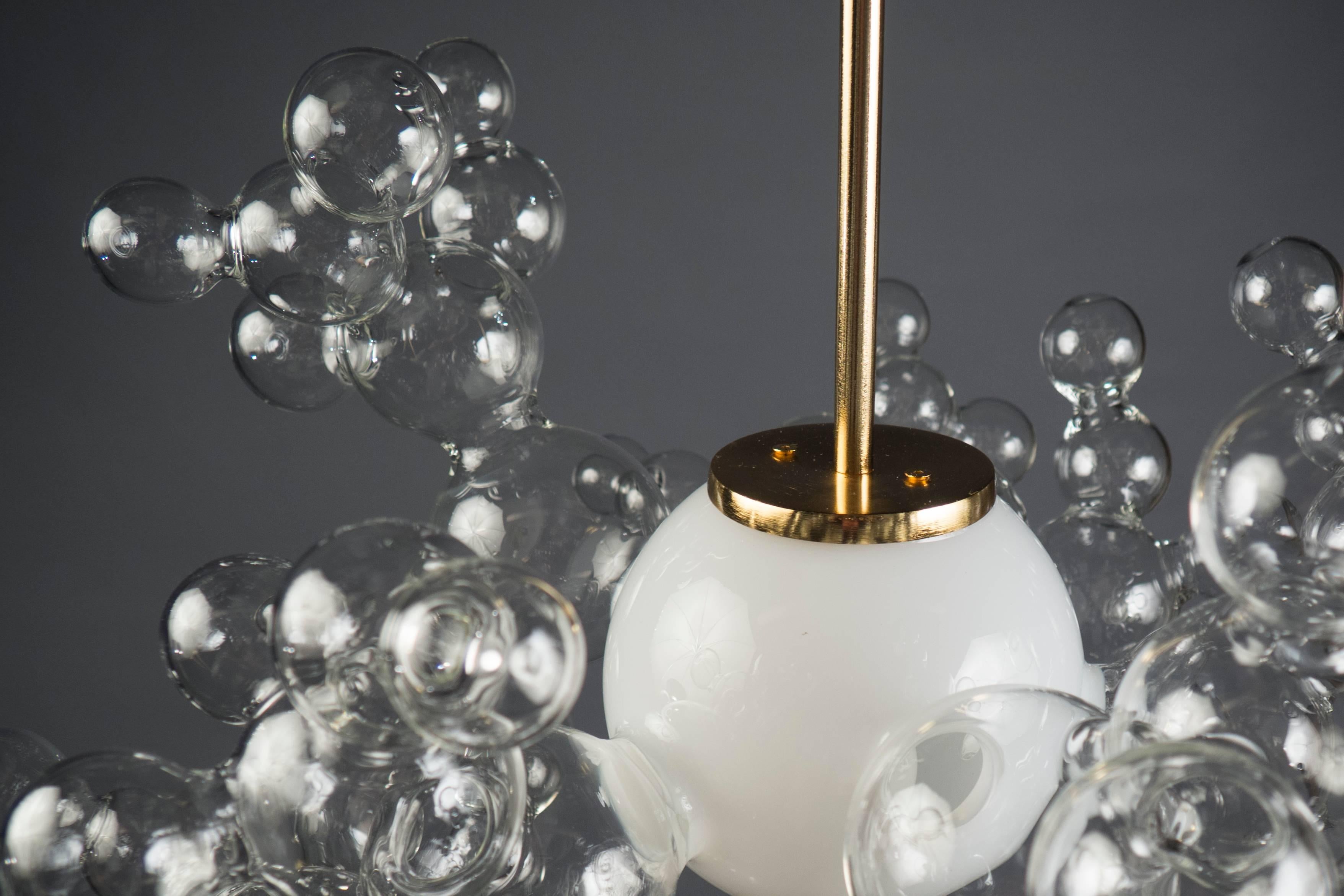 Single white glass globe surrounded by several bubble structures suspended from a 24-karat gold structure. Custom sizes and finishes available.

 Fixture height: 16”.
