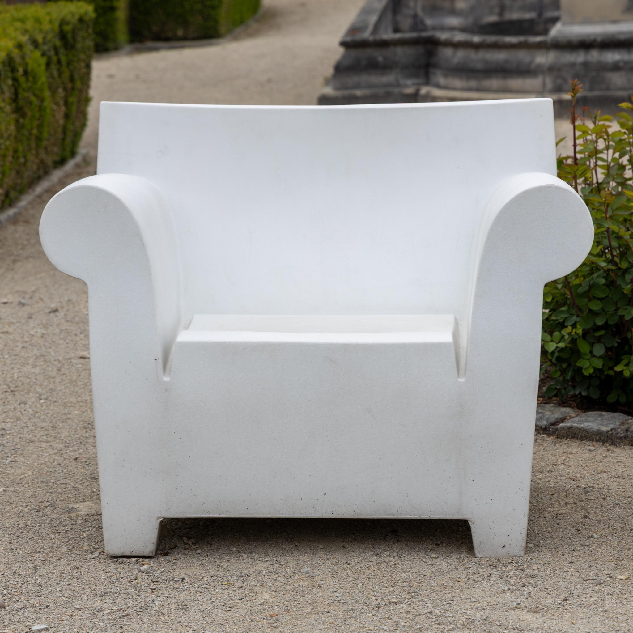Seating set designed by Philippe Starck for Kartell, made of weather-resistant plastic with a modern, sculptural design. Two spacious armchairs and a matching side table provide stylish comfort for outdoor use. Elegant, low-maintenance, and durable.