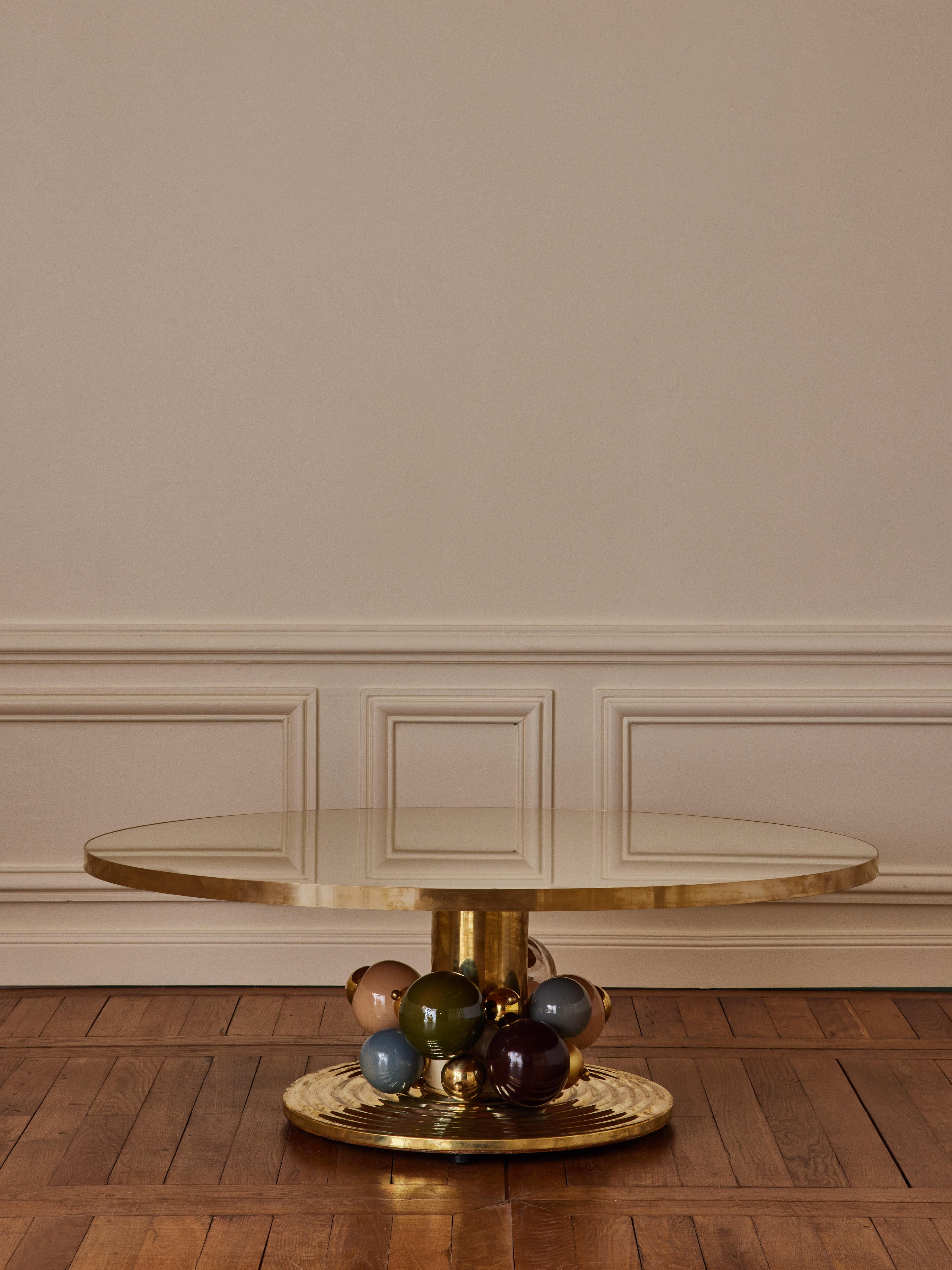 Brass coffee table with top in tainted mirror, and blown Murano glass globes.
Creation by Studio Glustin.