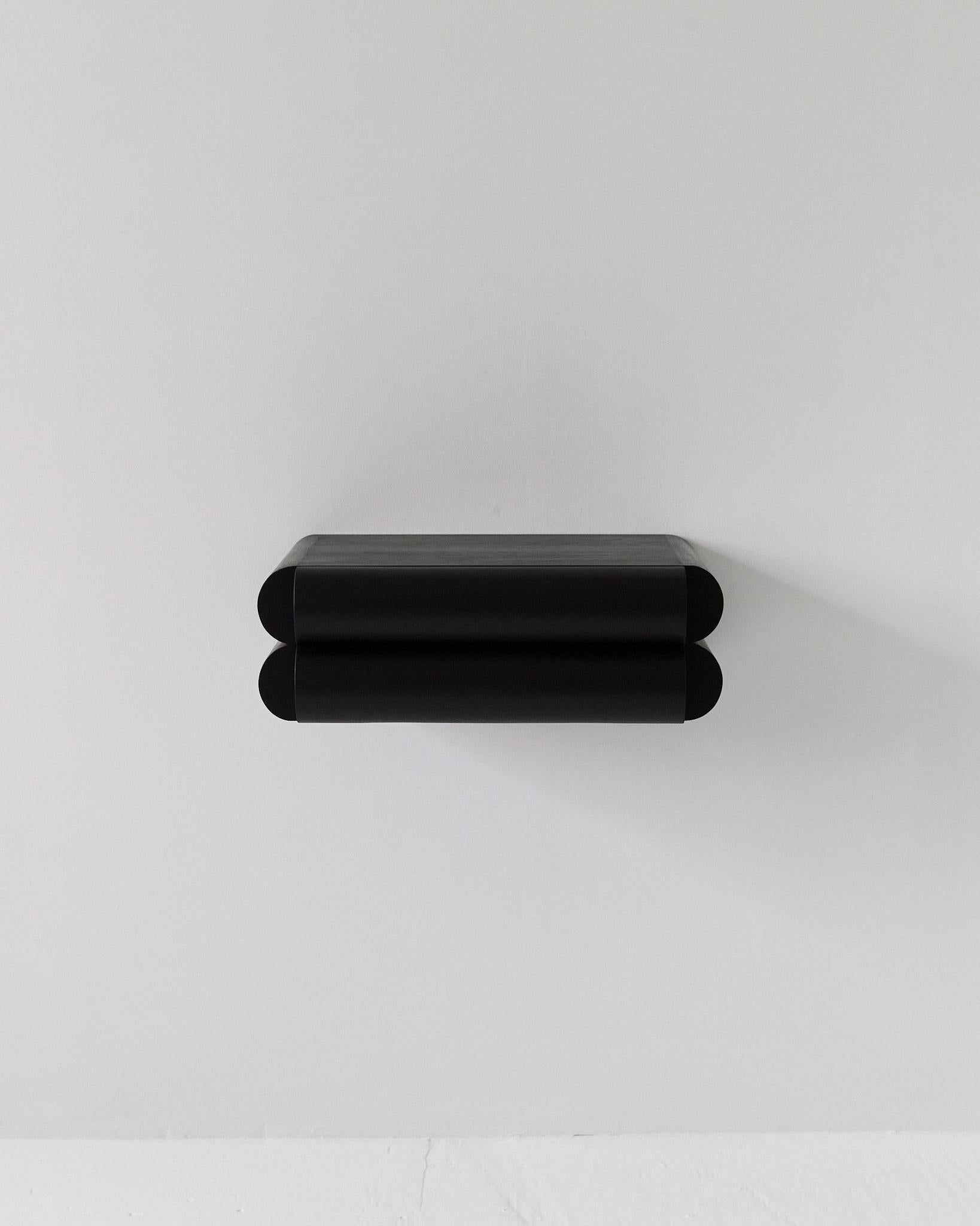 This small shelf with integrated drawer works perfectly as an entryway console or nightstand. The recessed handle pull keeps the design looking clean and sophisticated while camouflaging its function under a distinct and bold aesthetic.