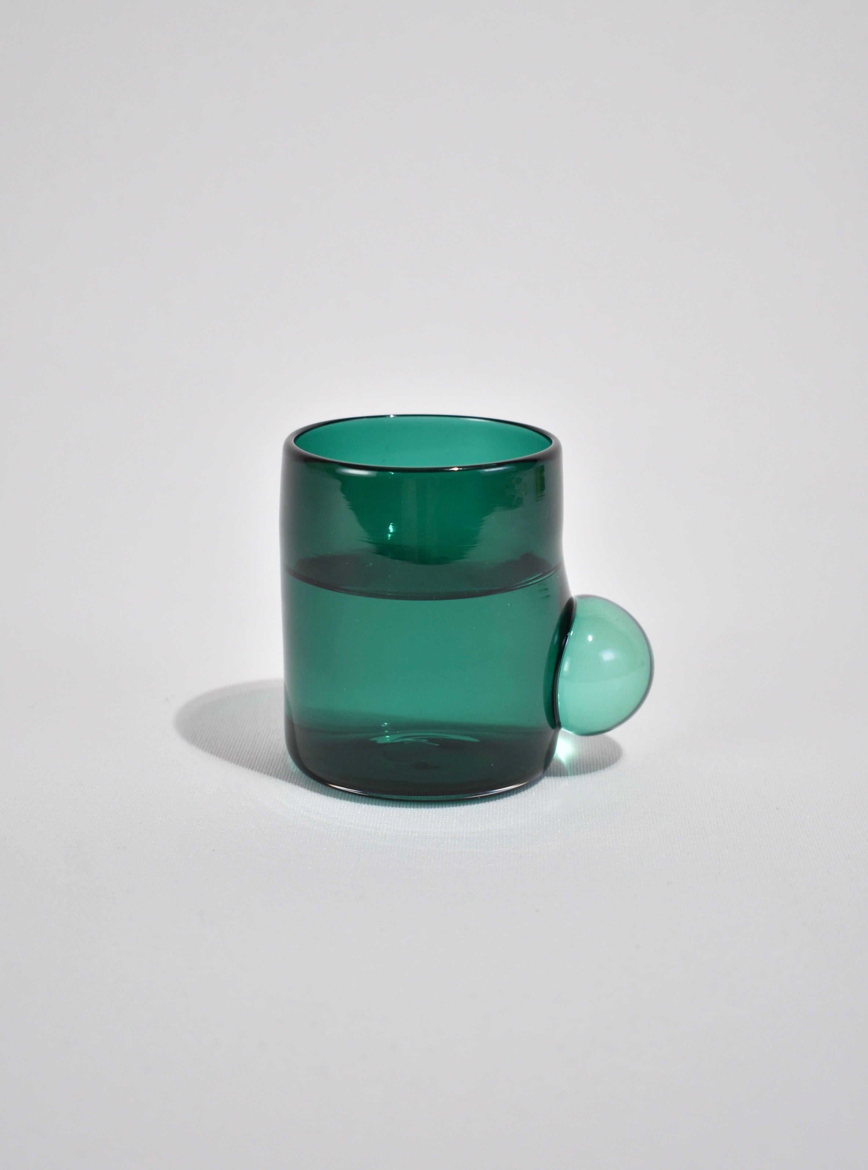 Blown glass tumbler in teal with a clear bubble handle. Perfect size for water, wine, juice, or spirits. Handmade in USA by Grace Whiteside of Sticky Glass.

Please note: Due to the handmade nature of this cup, subtle variations in form and finish