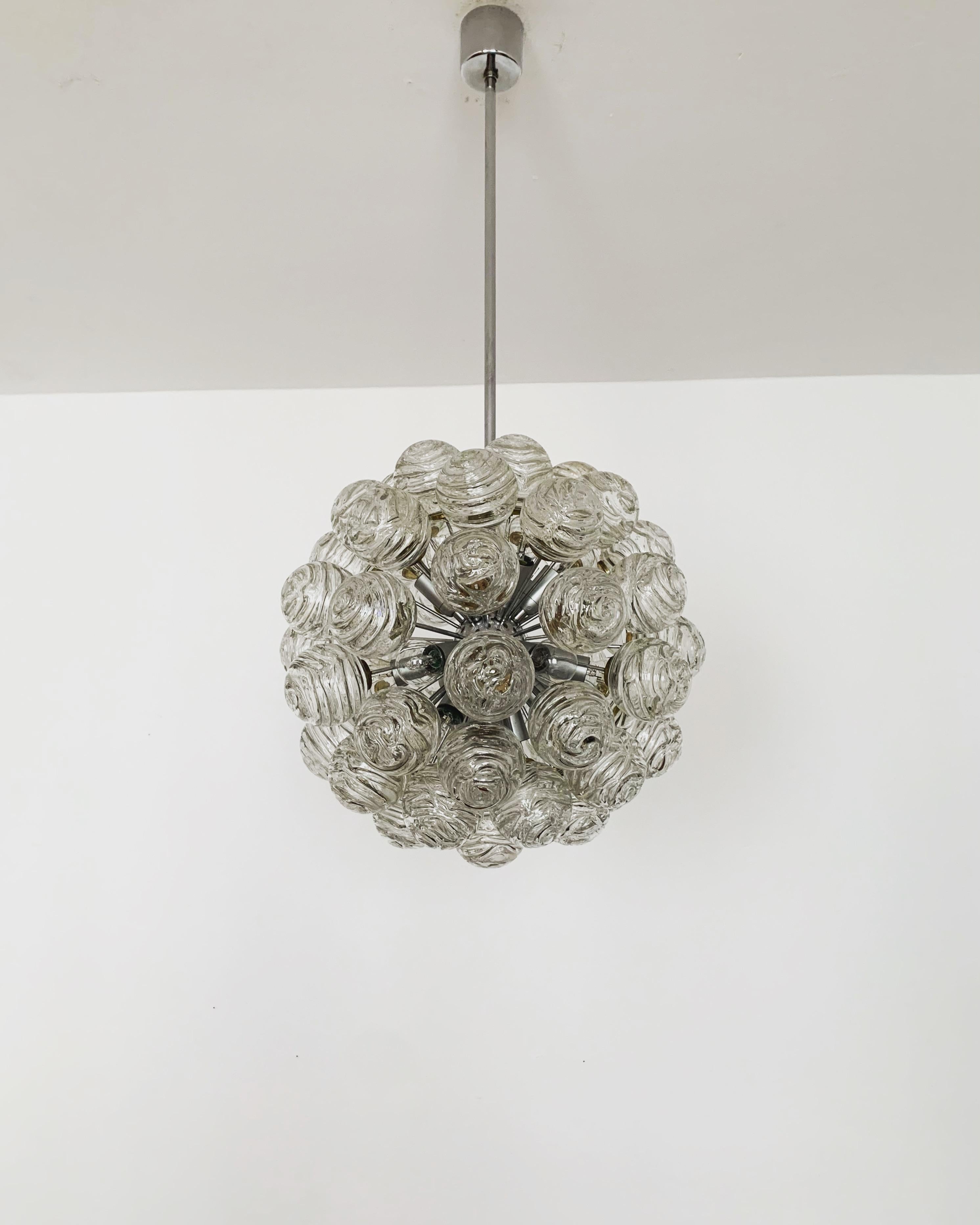 Favoloso lampadario Sputnik in vetro a bolle d'aria degli anni '60.
La lampada con le 55 sfere di vetro è molto nobile.
La struttura dei paralumi in vetro crea uno spettacolare gioco di luci.
Un vero e proprio colpo d'occhio.

Produttore:
