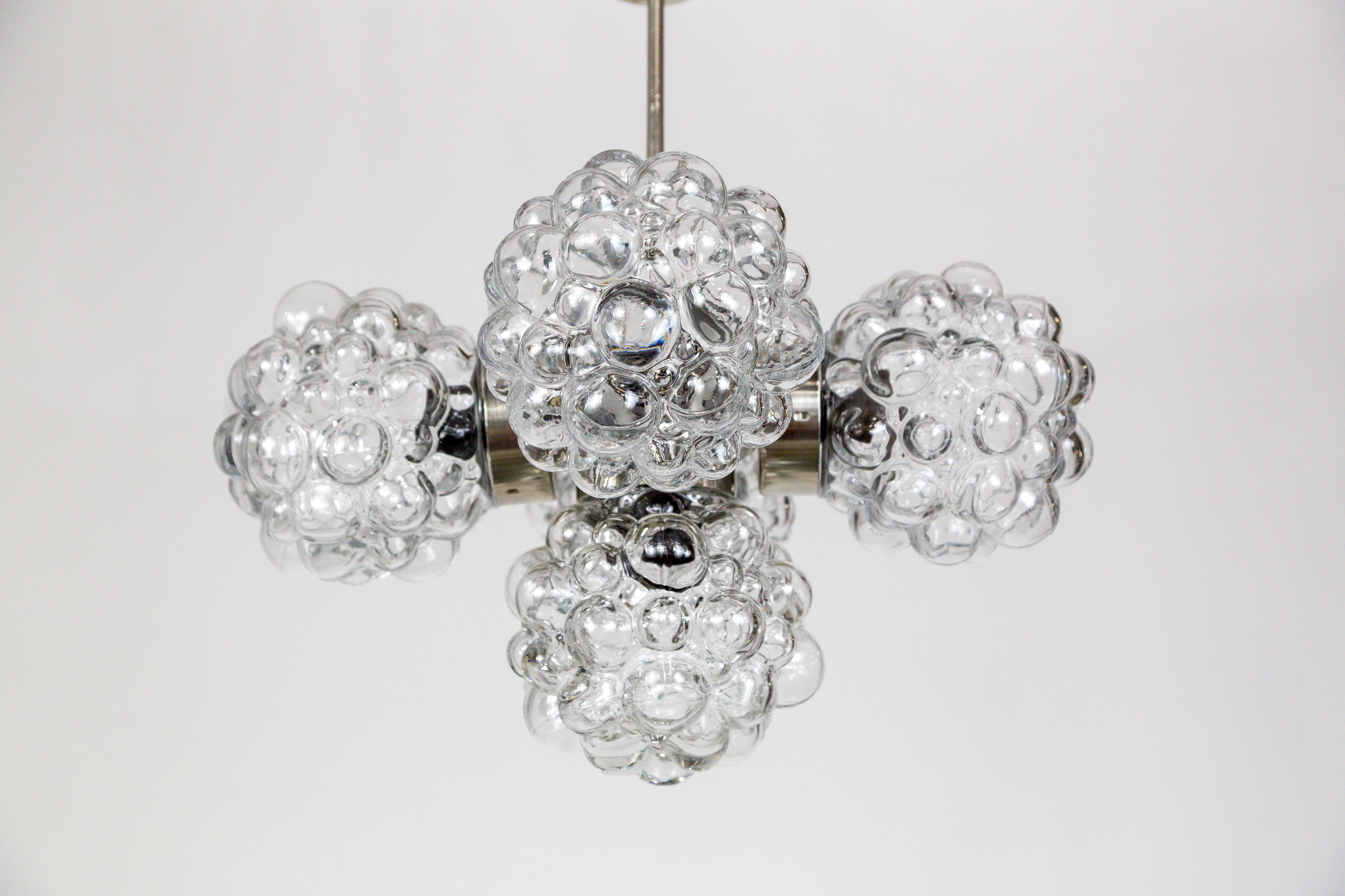 A gorgeous pendant light with five, molded glass bubble spheres, designed by Helena Tynell, and fabricated in the early 1970s in Germany by Limburg. The metal structure has a slick, chrome finish. It looks great in smaller spaces, and has a strong