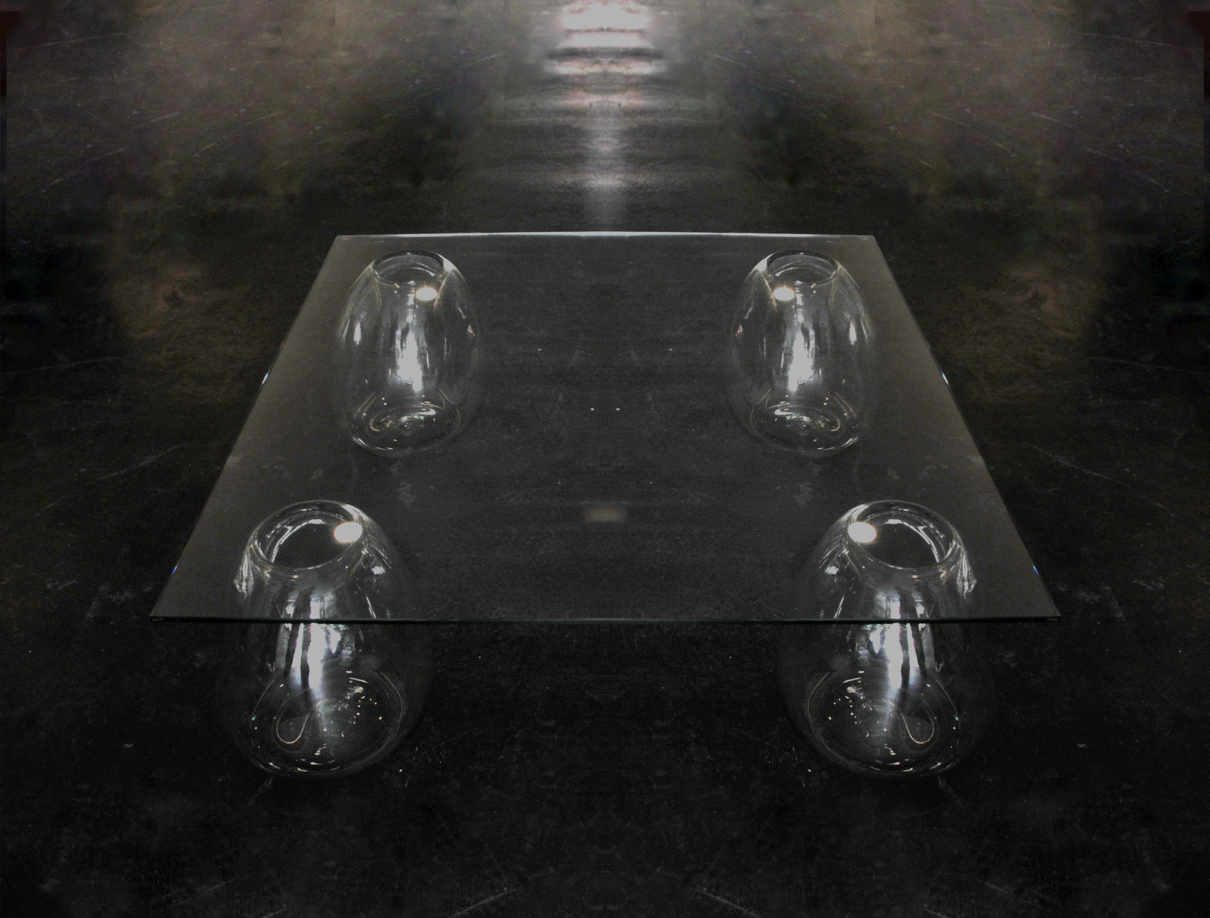 La table basse en verre Bubble incarne une fantaisie rétro-futuriste. Inspiré par des visions passées de l'avenir, il s'inspire de récits mystérieux de technologies spéculatives et de soucoupes volantes. Ses formes épurées et élégantes évoquent une