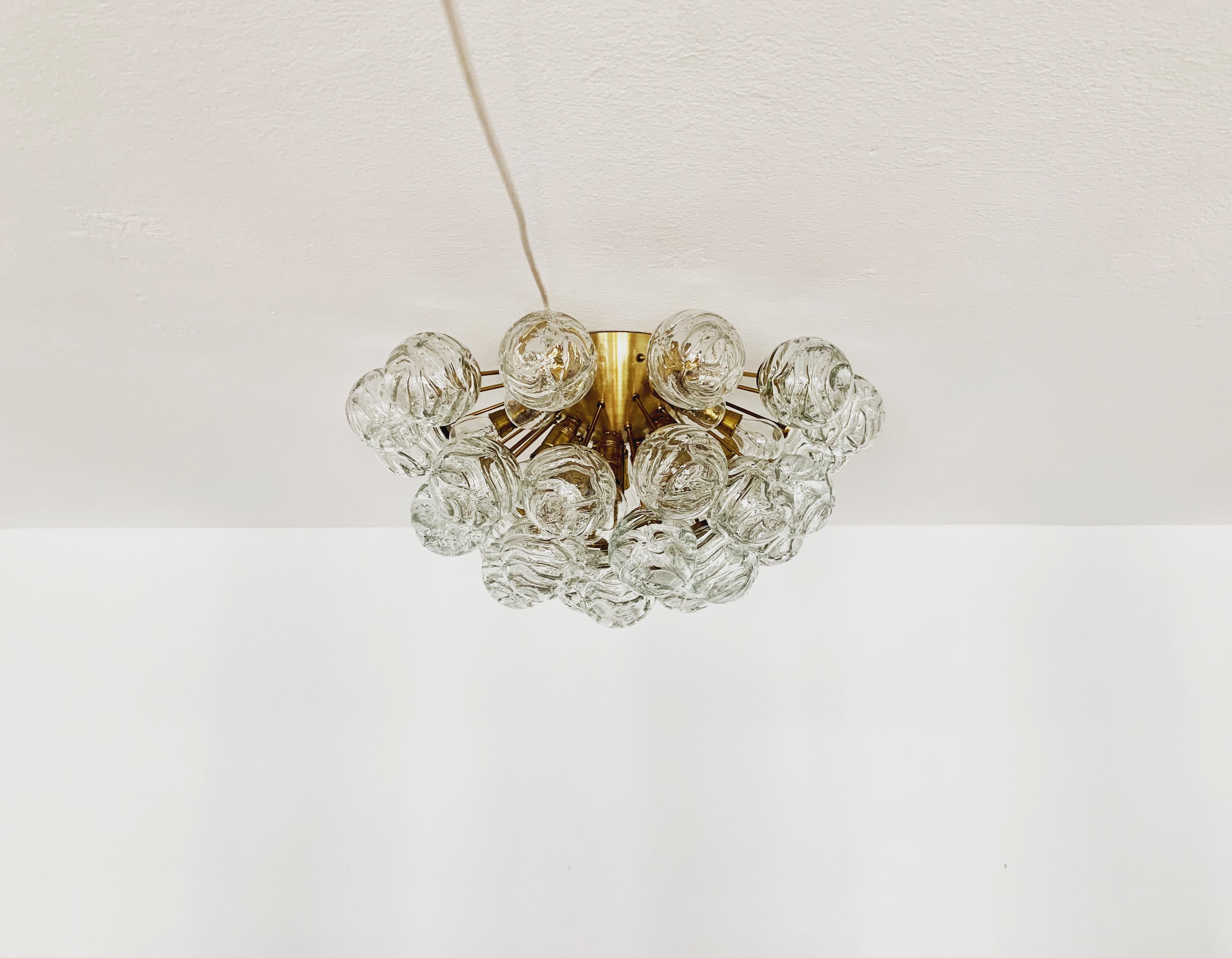 Fabuloso plafón o aplique de cristal de hielo dorado de los años 60.
La lámpara con las 31 bolas de cristal tiene mucha clase.
La estructura de las pantallas de cristal crea un espectacular juego de luces.
Una atracción absoluta.

Estado:

Muy buen