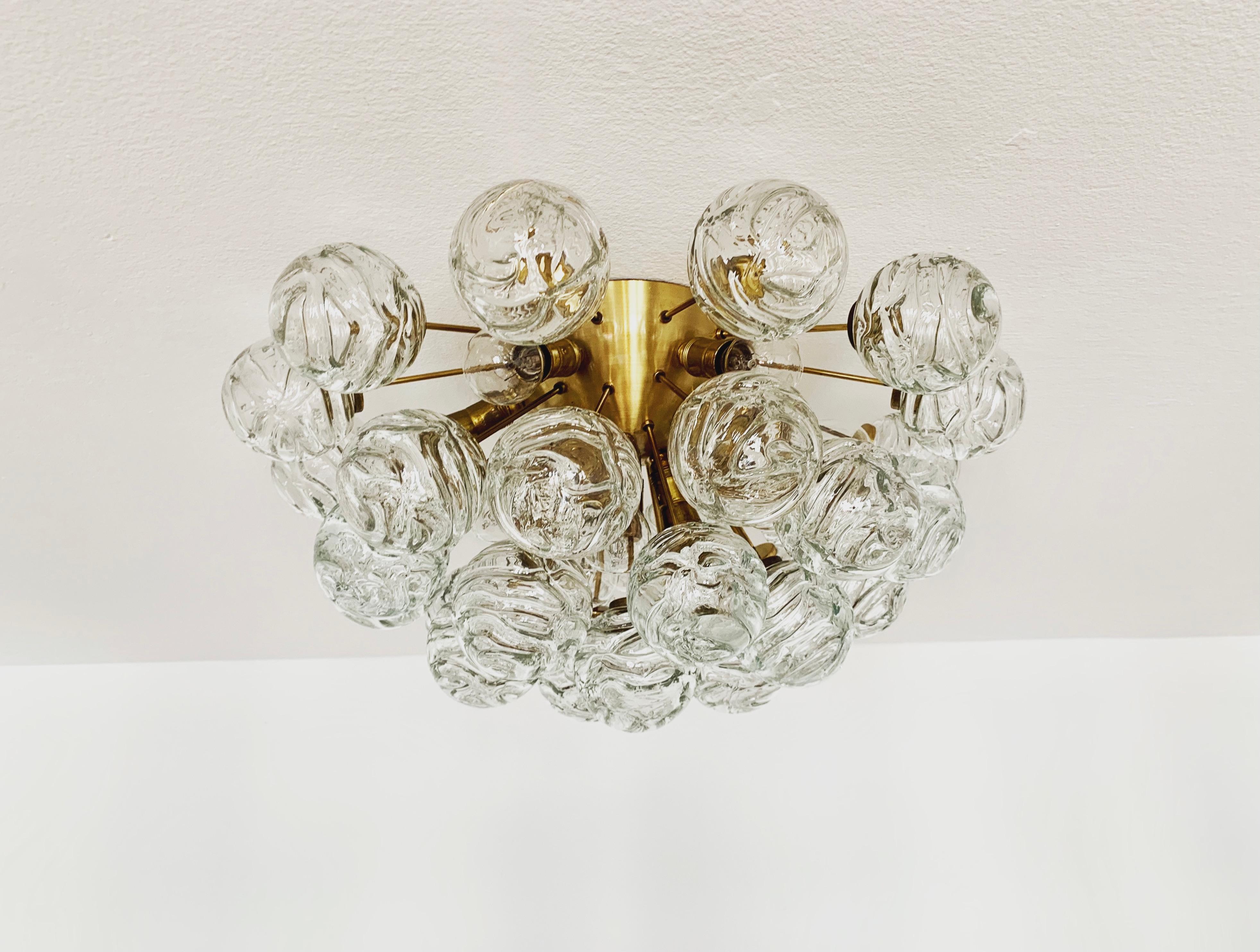 Fabulous golden ice glass ceiling lamp from the 1960s.
The lamp with its 31 glass globes is very elegant.
The structure of the glass shades creates a spectacular play of light.
A real eye-catcher.

Manufacturer: Doria
Circa 1960

Condition:

Very