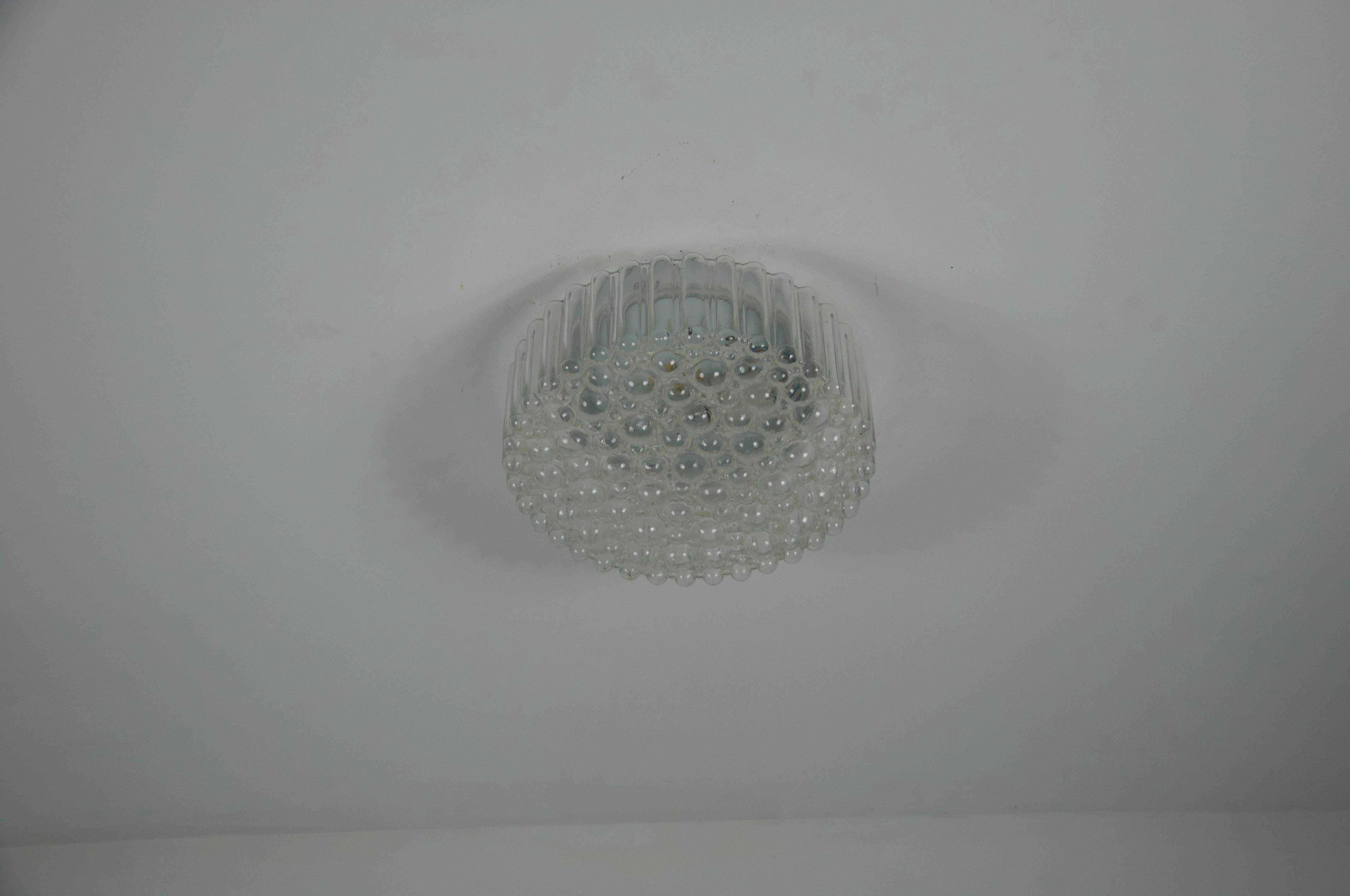 Questa elegante plafoniera da incasso è stata prodotta dal rinomato produttore tedesco Glashütte Limburg negli anni Sessanta. Caratterizzato da un bellissimo paralume in vetro a bolle, questo pezzo esemplifica la maestria e la sensibilità del design