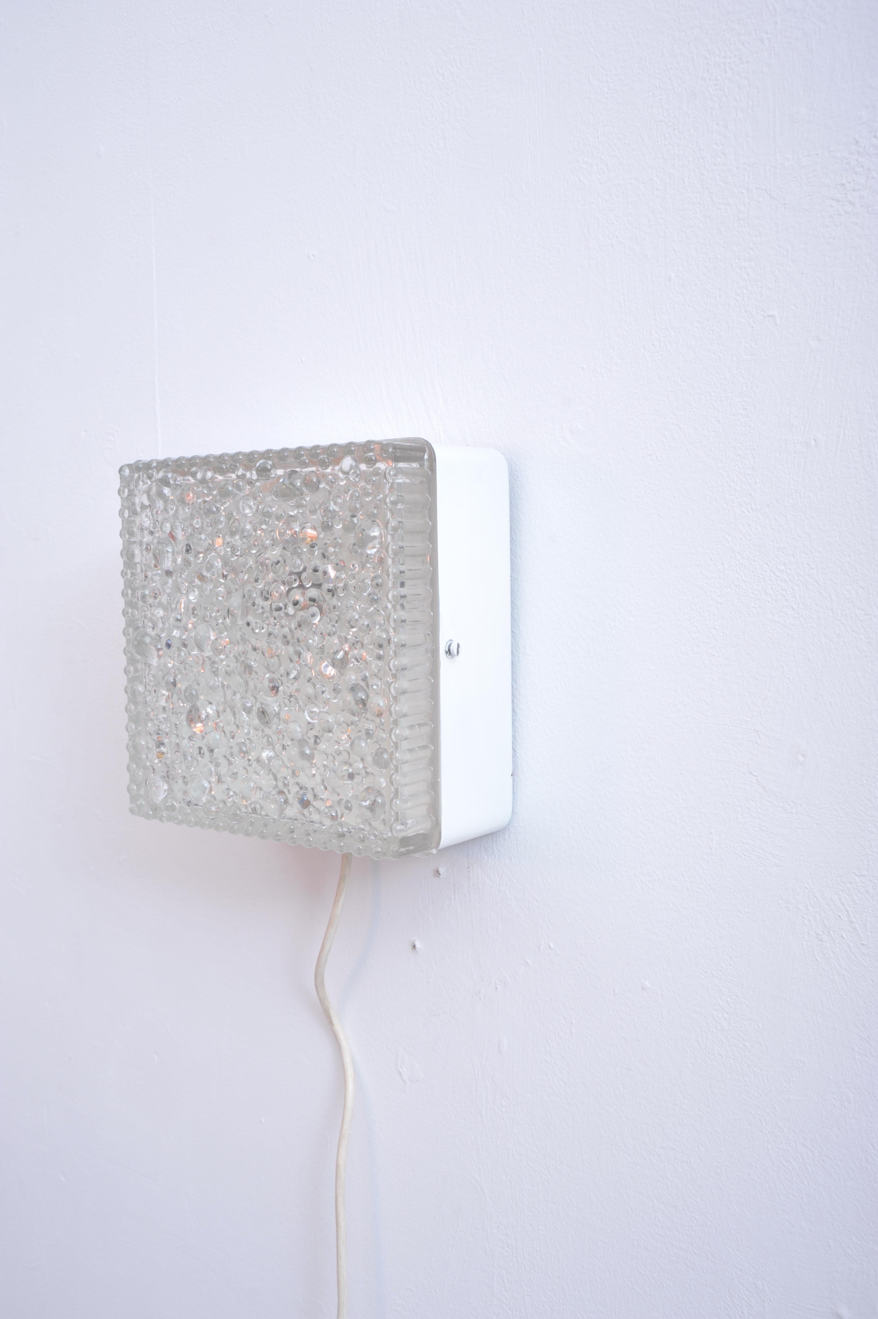 Classic German mid-century wall light designed by Staff in the 1960s. Featuring a textured bubble glass diffuser, it provides soft, diffused illumination while adding sculptural elegance to any interior. The metal housing reflects the clean,