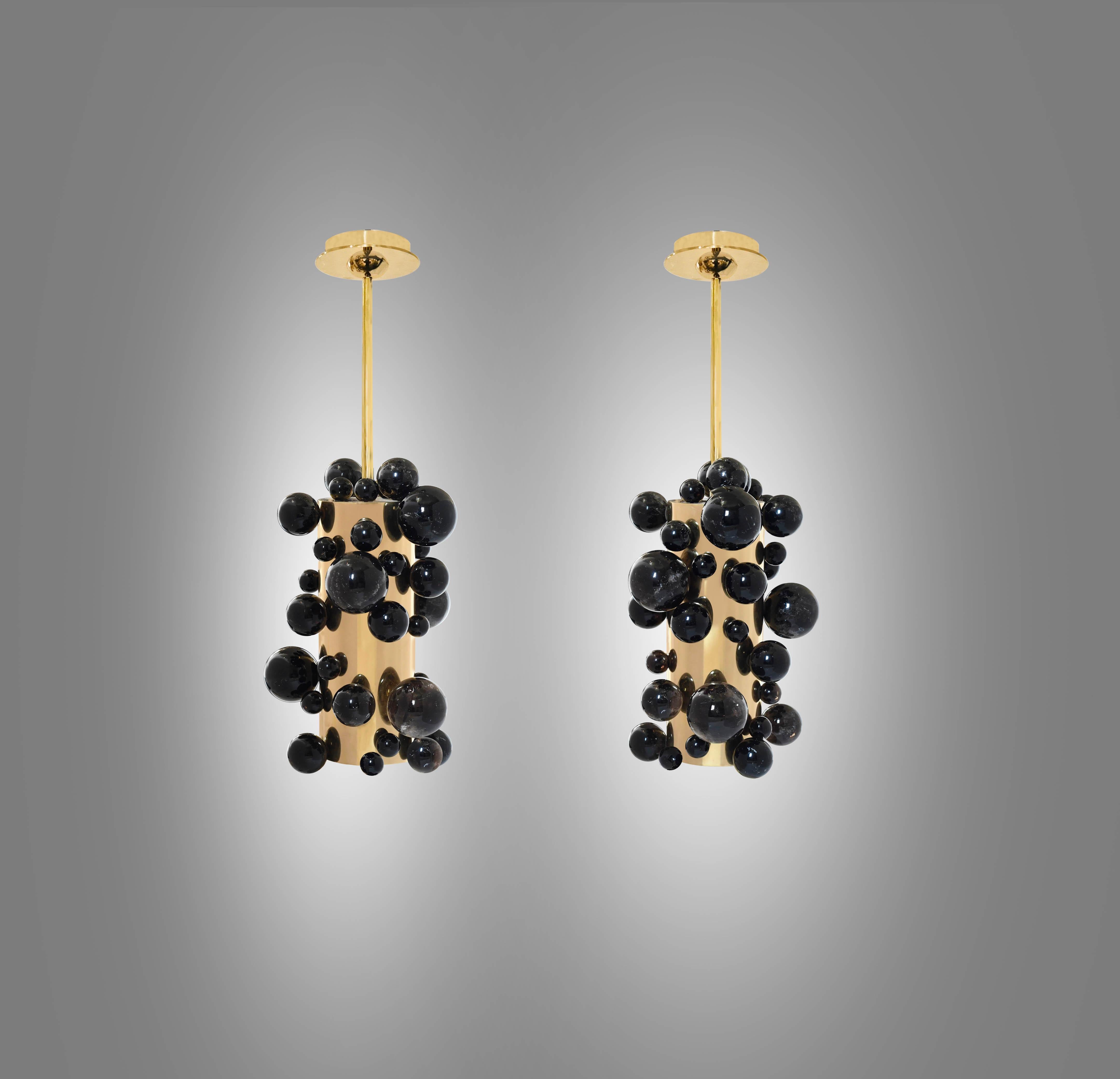 Pair of smoky rock crystal bubble pendant lights with polished brass finishes. Created by Phoenix Gallery, NYC.
One socket installed each light. Use LED warm light bulbs. 80w each. 
Dimension of the pendant: 8