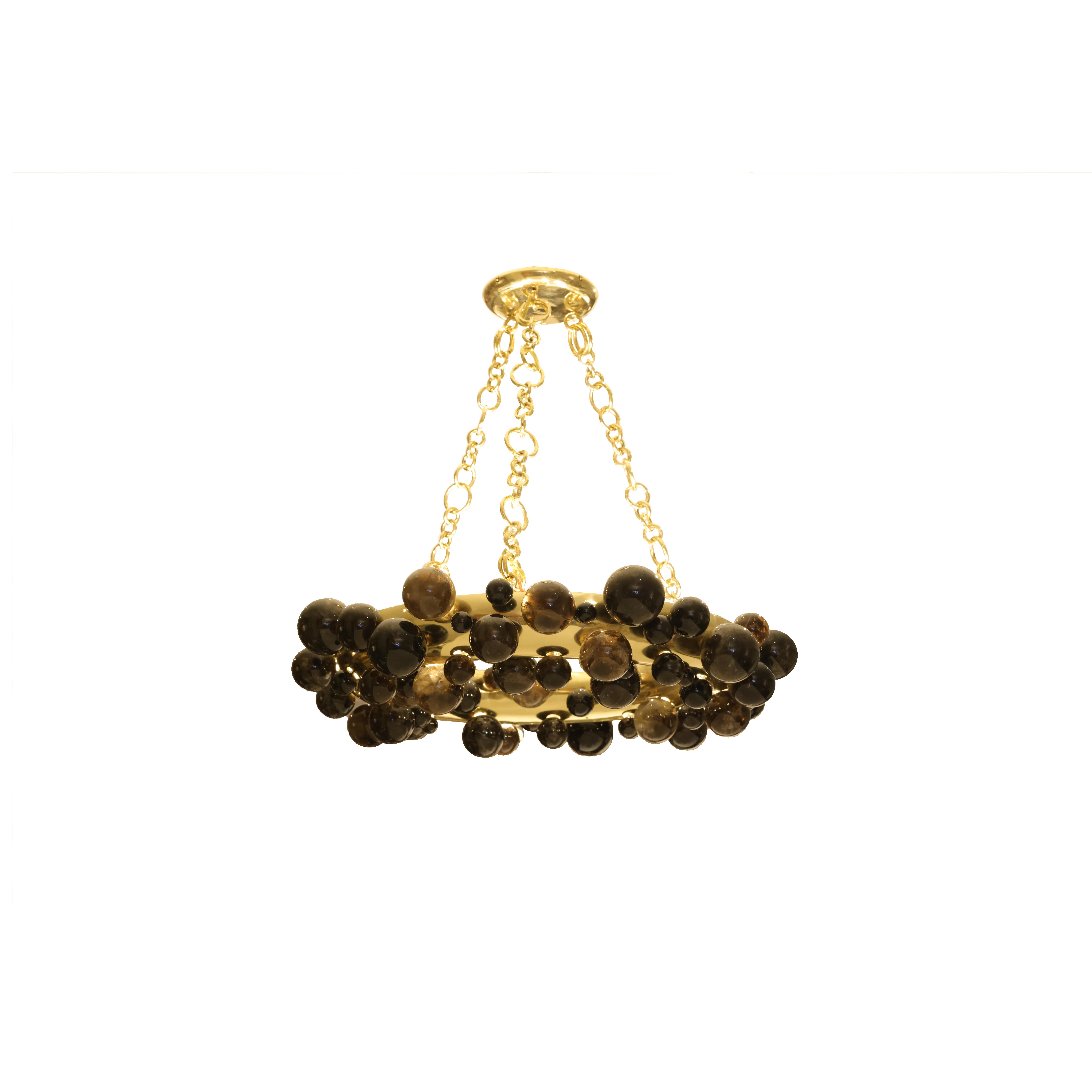 A pair of bubble ring rock crystal chandeliers with polish brass frame. Created by Phoenix Gallery, NYC.
Each chandelier install 10 sockets. Use 60w LED warm light bulbs. Total of 600w. 
Custom size and metal finish upon request.
 
