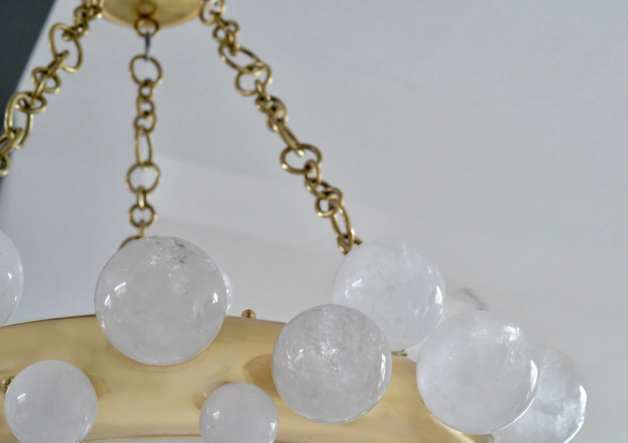 Une paire de lustres en cristal de roche à anneau de bulle avec une structure en laiton poli. Créé par Phoenix Gallery, NYC.
Chaque lustre installe 10 douilles. Utilisez des ampoules LED chaudes de 60w. Total de 600w. 
Taille et finition du métal