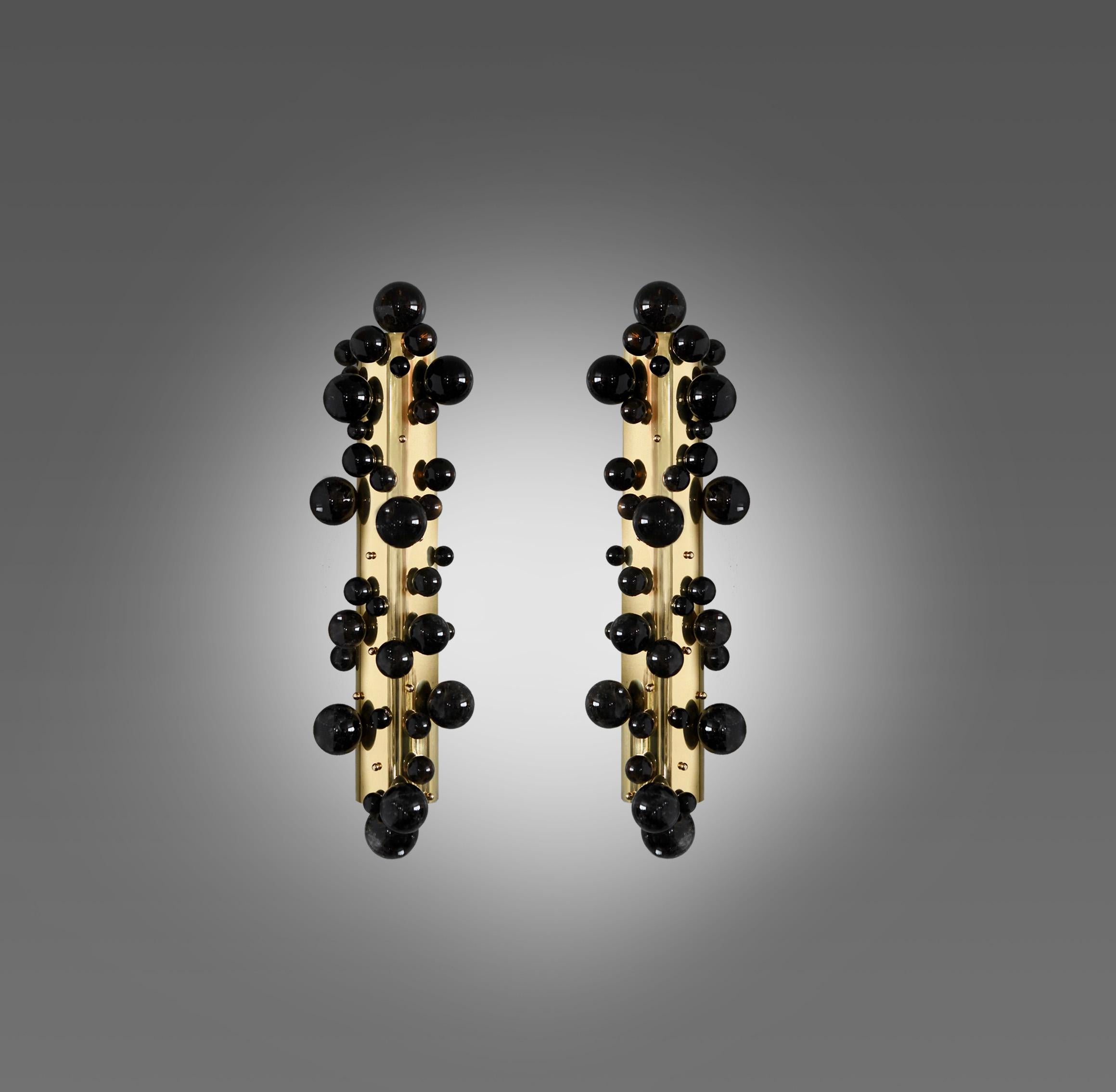 Pareja de apliques de cristal de roca burbuja oscura con acabados de latón pulido. Creado por Phoenix gallery NYC.
Cada candelabro instaló cuatro casquillos. Utiliza cuatro bombillas LED de 60 vatios de luz cálida. Total 240w máx. Bombillas