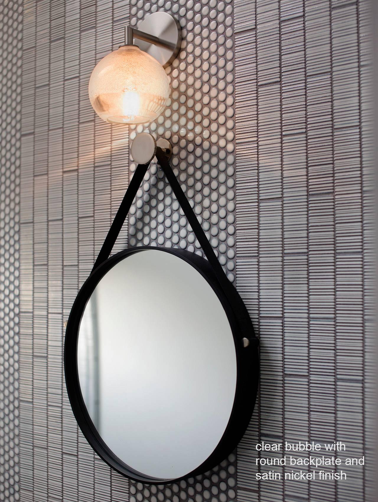 This series of wall sconces is classically inspired. Scaled versions of our pendants extend from elegant metal armatures. The proximity of the glass to the wall allows for each piece’s unique light pattern to be magnified. Hand blown and shaped in