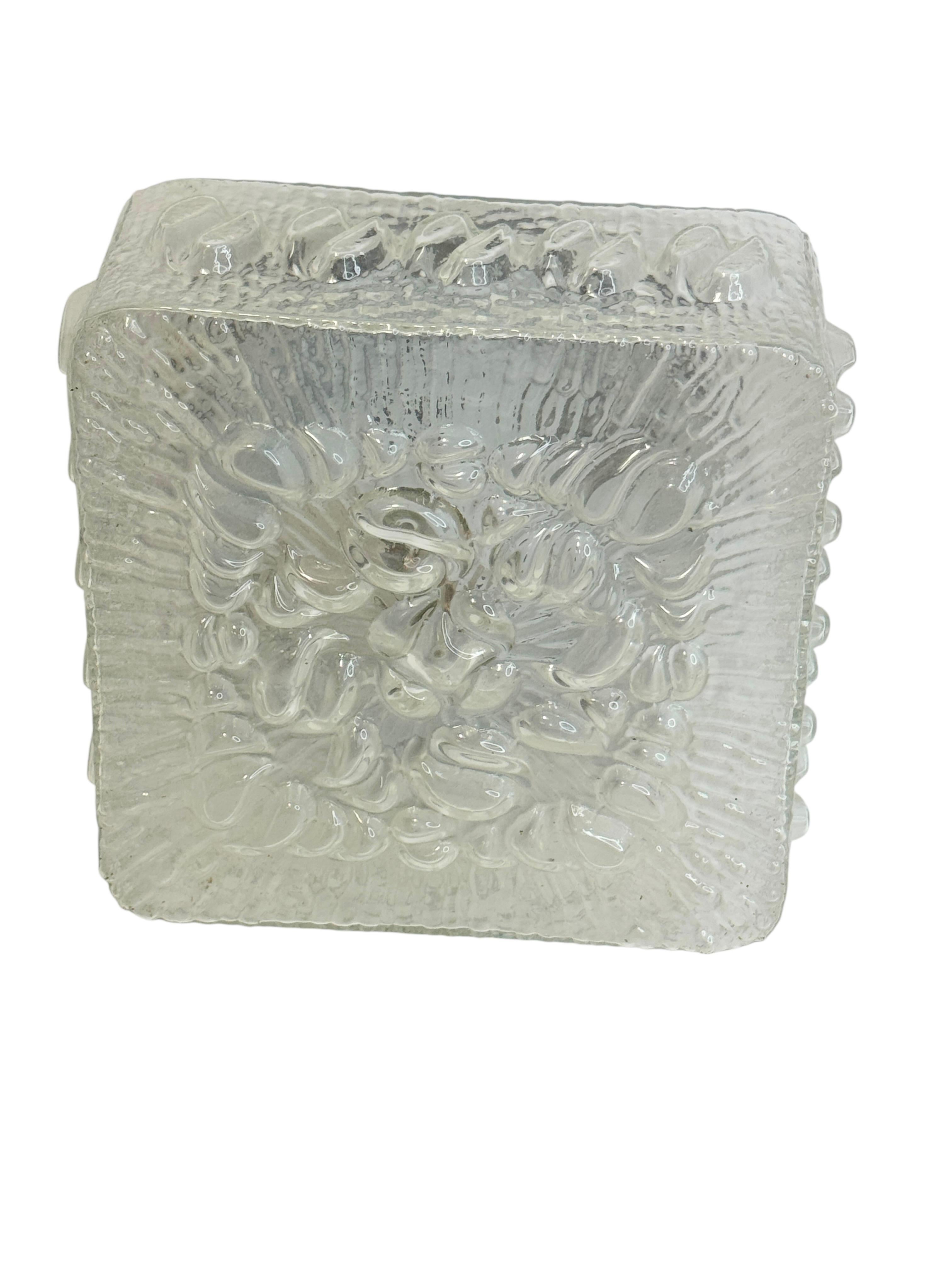 Una hermosa montura empotrada de Massive Leuchten, Alemania. Precioso empotrable de cristal transparente texturizado con soporte metálico. La luminaria requiere una bombilla europea E27 Edison o mediana de hasta 60 vatios. Encontrado en una venta de