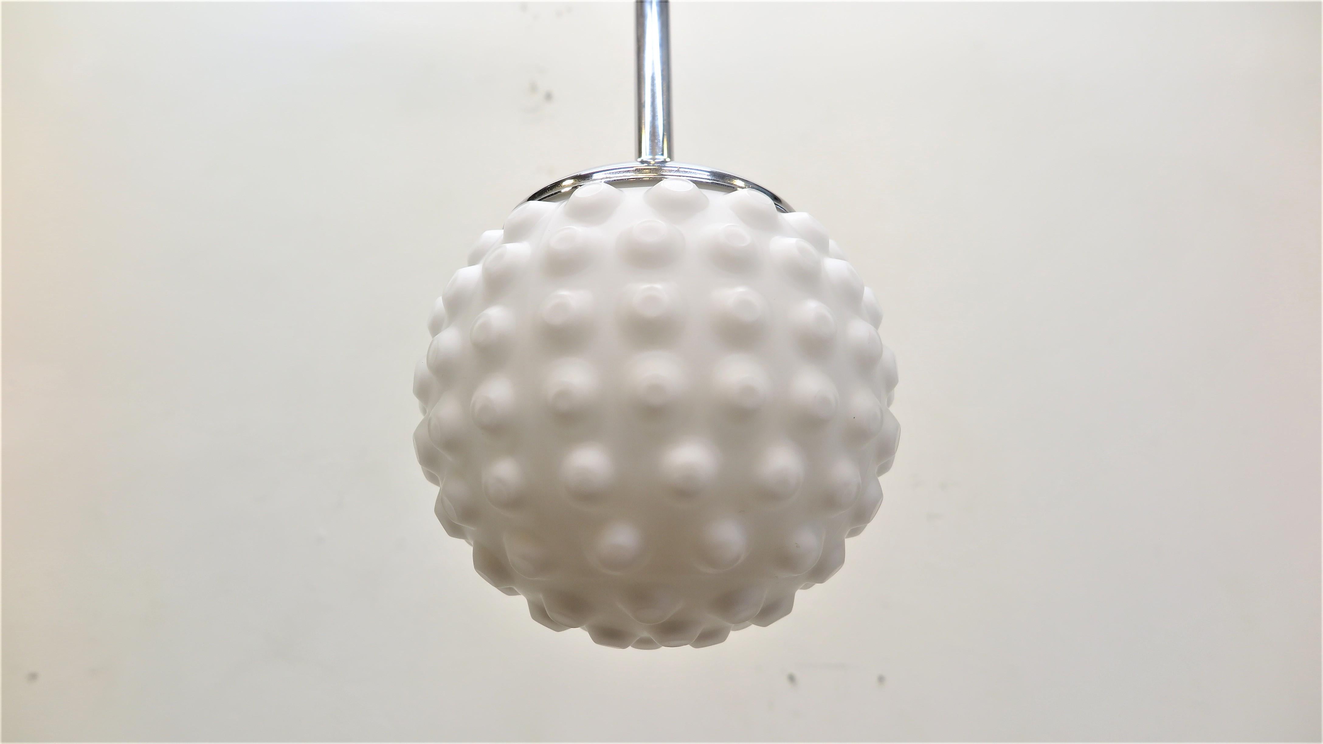 Bubble Sphere Frosted White glass pendant.  Milk Glass ball pendant light on chrome shaft made in Germany, Doria Leuchten, 1970s. Textured Bubble type molded white frosted glass Sphere pendant light having adjustable height. The current wire allows