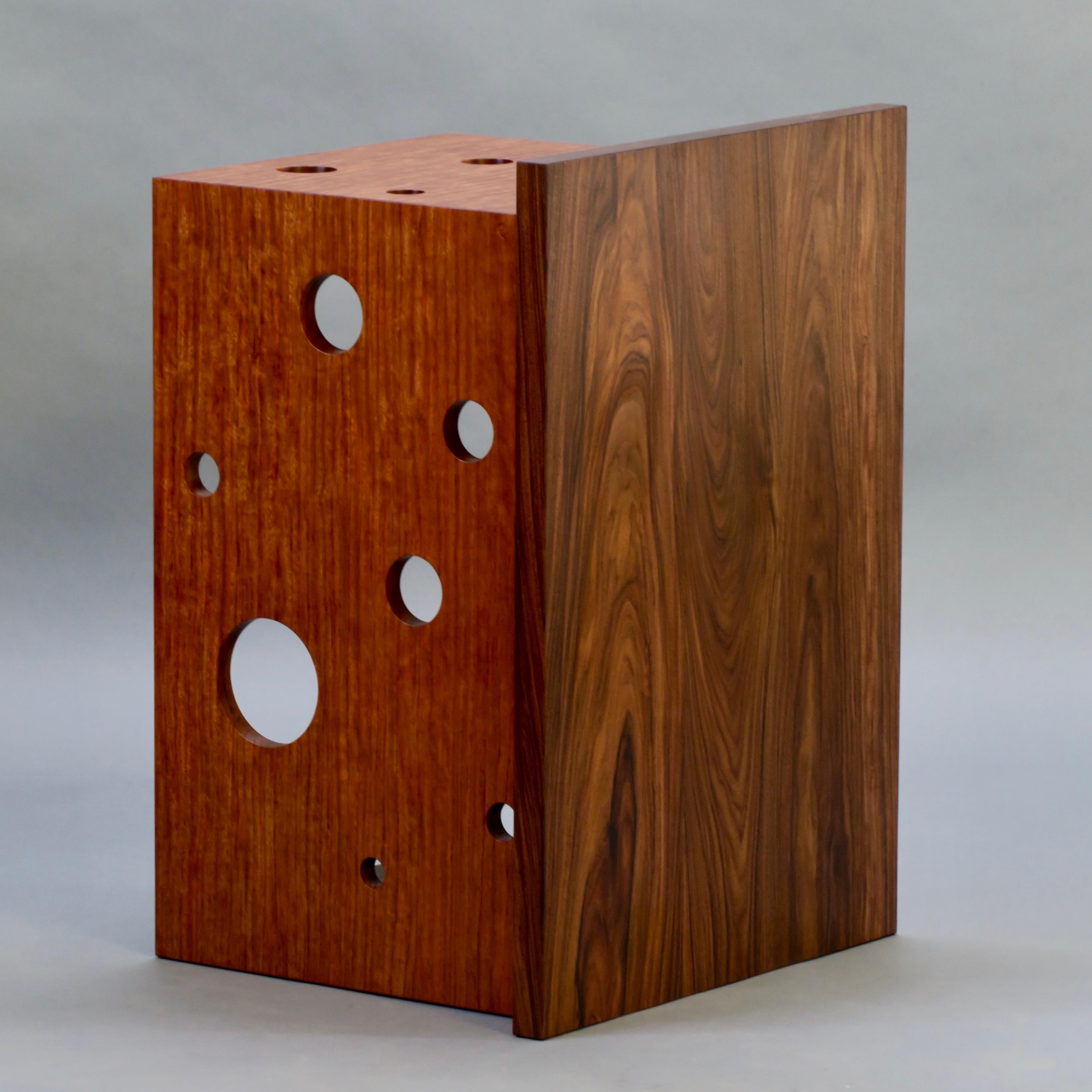 La table d'appoint Oriel VI se caractérise par un plateau en porte-à-faux et des pieds joints en cascade en bubinga hautement figuré qui a été perforé de 