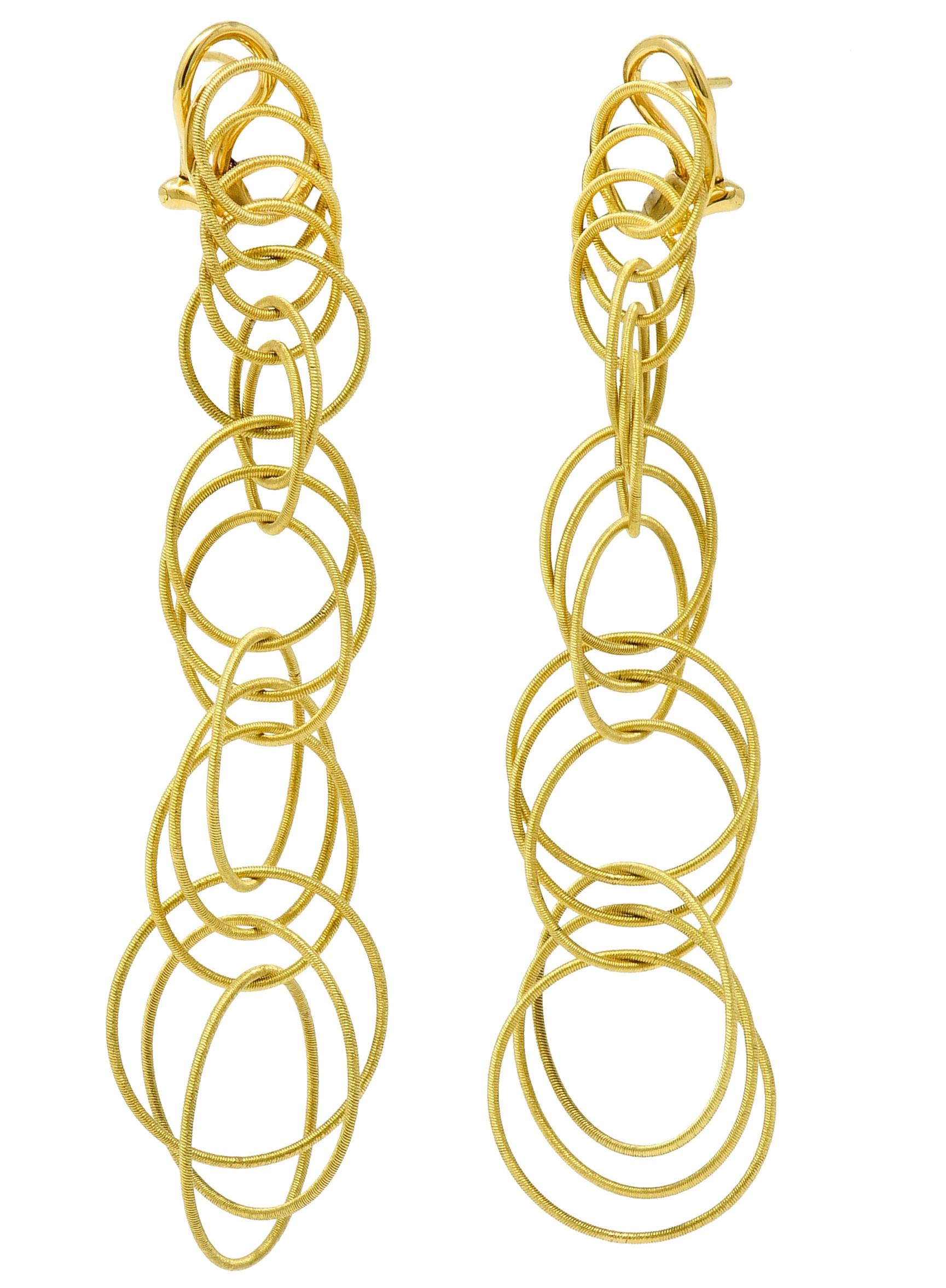 Drop earrings are comprised of light and springy gold circles

Layered, intersecting, and graduating in size

With a fine ribbed texture throughout

Completed by posts and hinged omega backs

With Italian assay marks for 18 karat gold

Signed