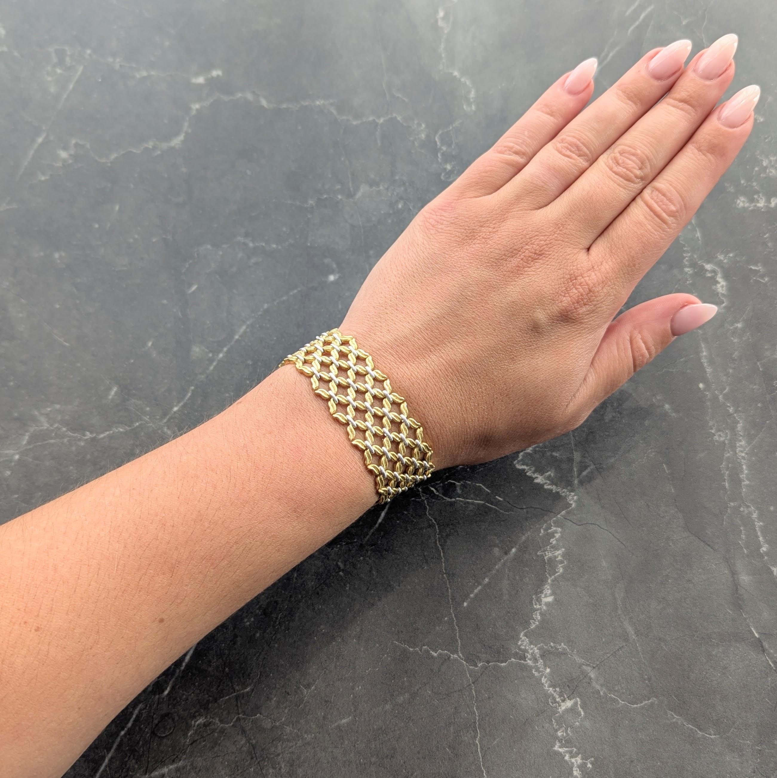 Comprised of yellow gold 'X' shaped links grooved to mimic fabric
Cinched by white gold midsections
With matte finish throughout
Completed by press release closure
With hinged figure eight safety
Stamped with Italian assay marks for 18 karat