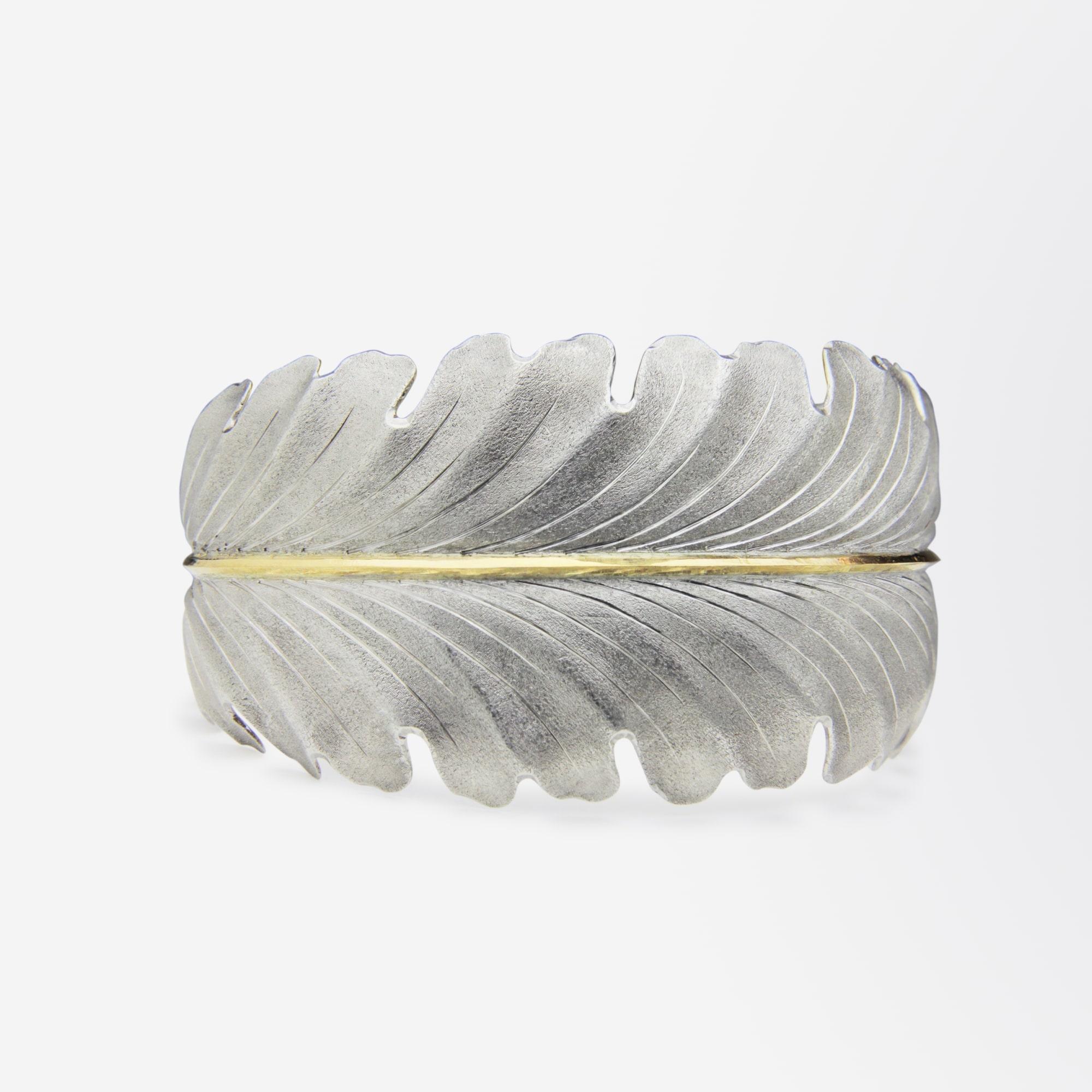 A handcrafted cuff in the form of an acanthus leaf by Gianmaria Buccellati. The piece is formed from sterling silver with a central vein of 18 karat yellow gold. The matte 'Florentine' finish to the piece has a silky smooth appearance and texture.